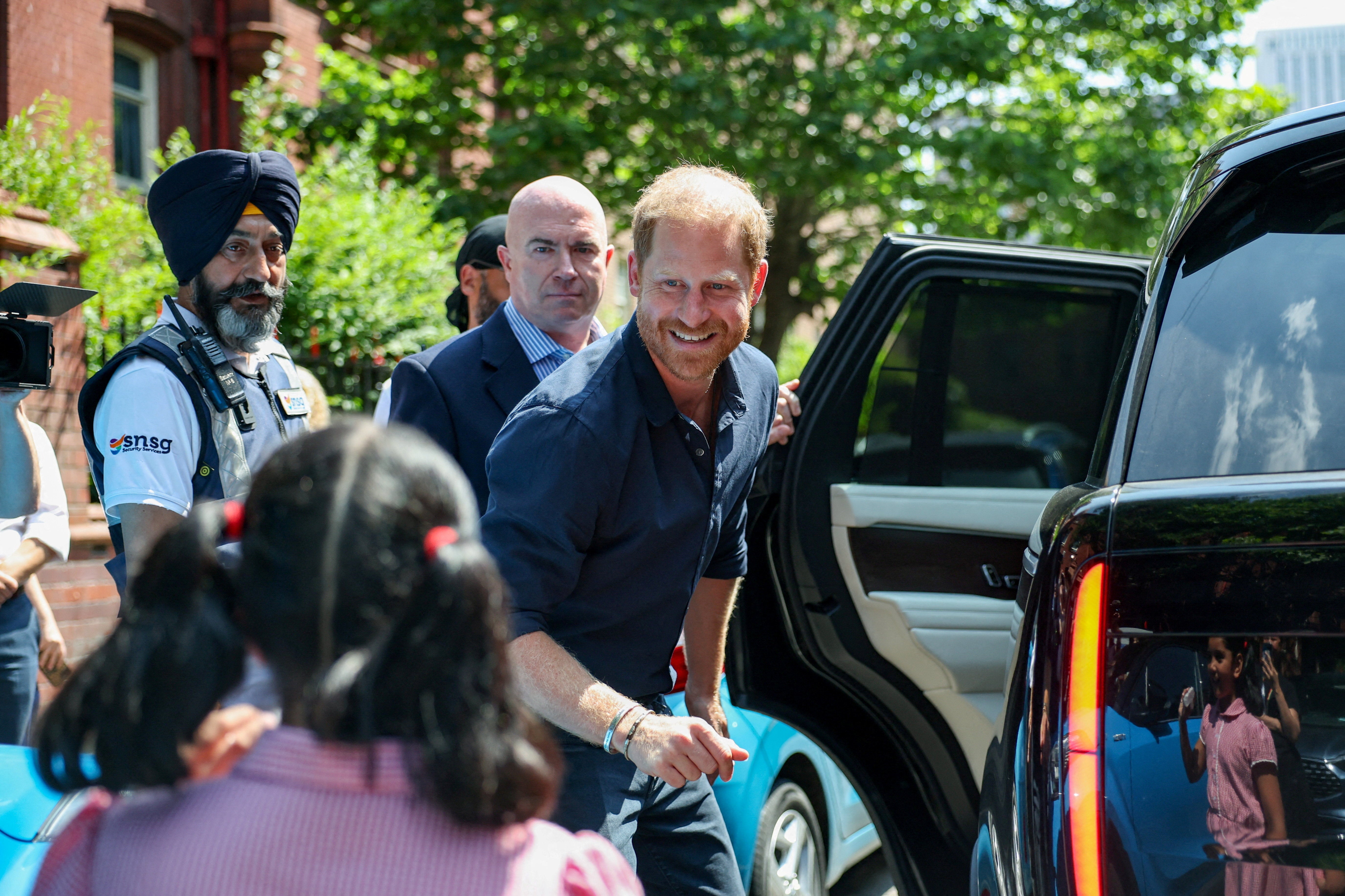 El príncipe Harry de Gran Bretaña saluda a un niño al salir del Hospital Infantil de Birmingham tras celebrar el vigésimo aniversario del primer programa de enfermeras de WellChild