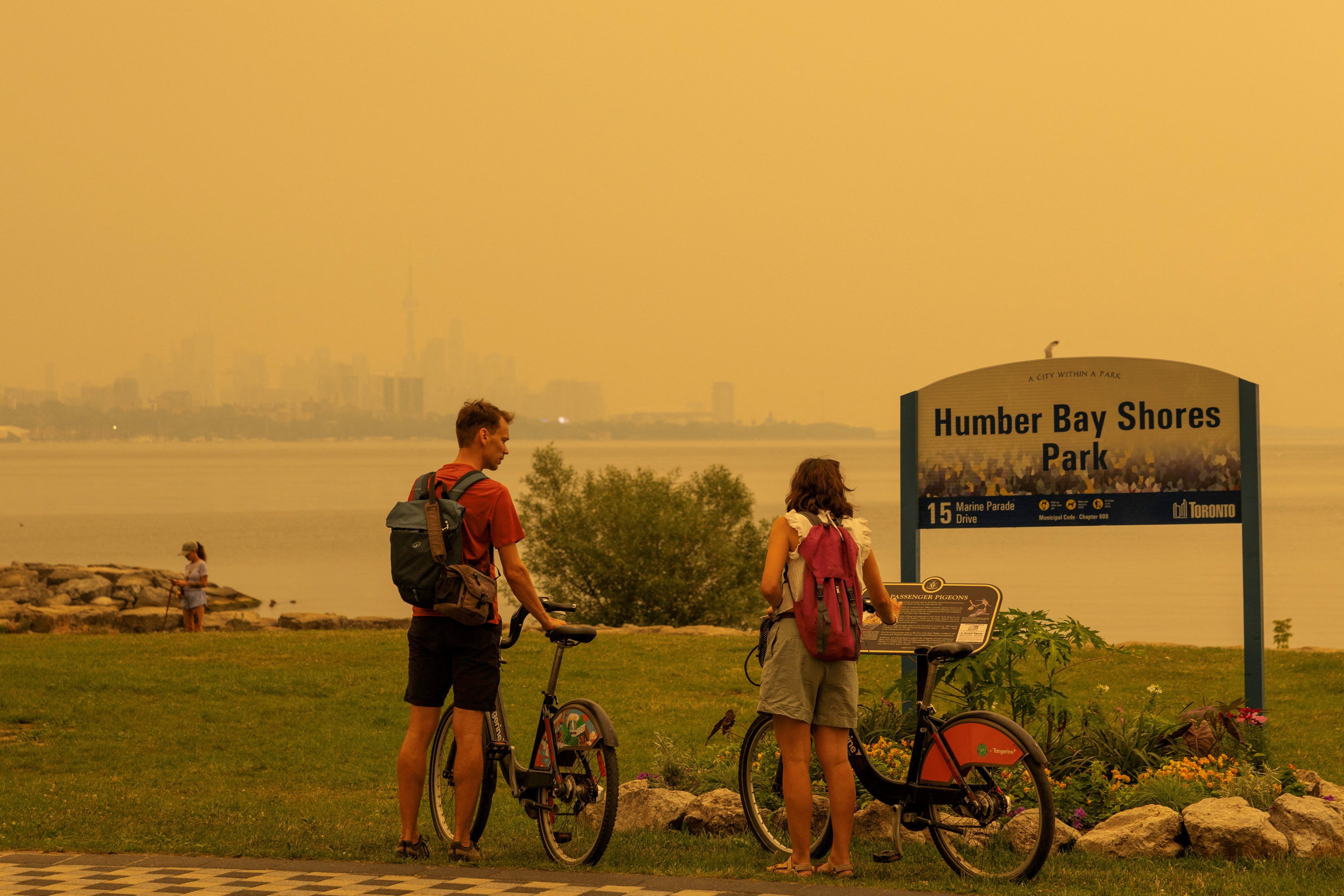 Personas disfrutan de un parque mientras el humo de los incendios forestales del noroeste de Ontario cubre el cielo de Toronto, Canadá, el miércoles. Cientos de incendios forestales en Canadá están enviando densas columnas de humo hacia Estados Unidos.