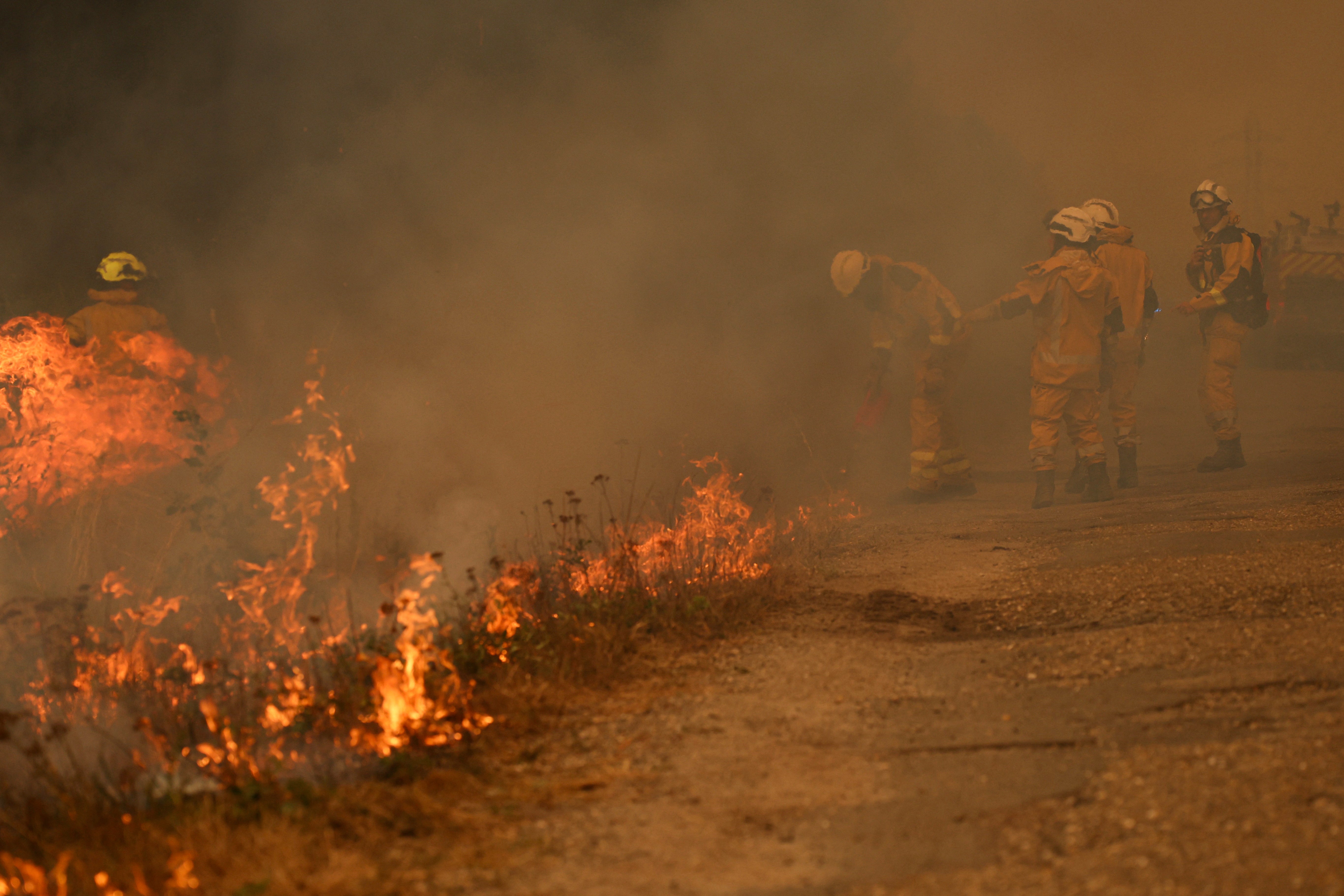 Los bomberos queman vegetación para crear una zona de amortiguación libre de combustible mientras combaten un enorme incendio forestal en Marcheprime, al oeste de Burdeos