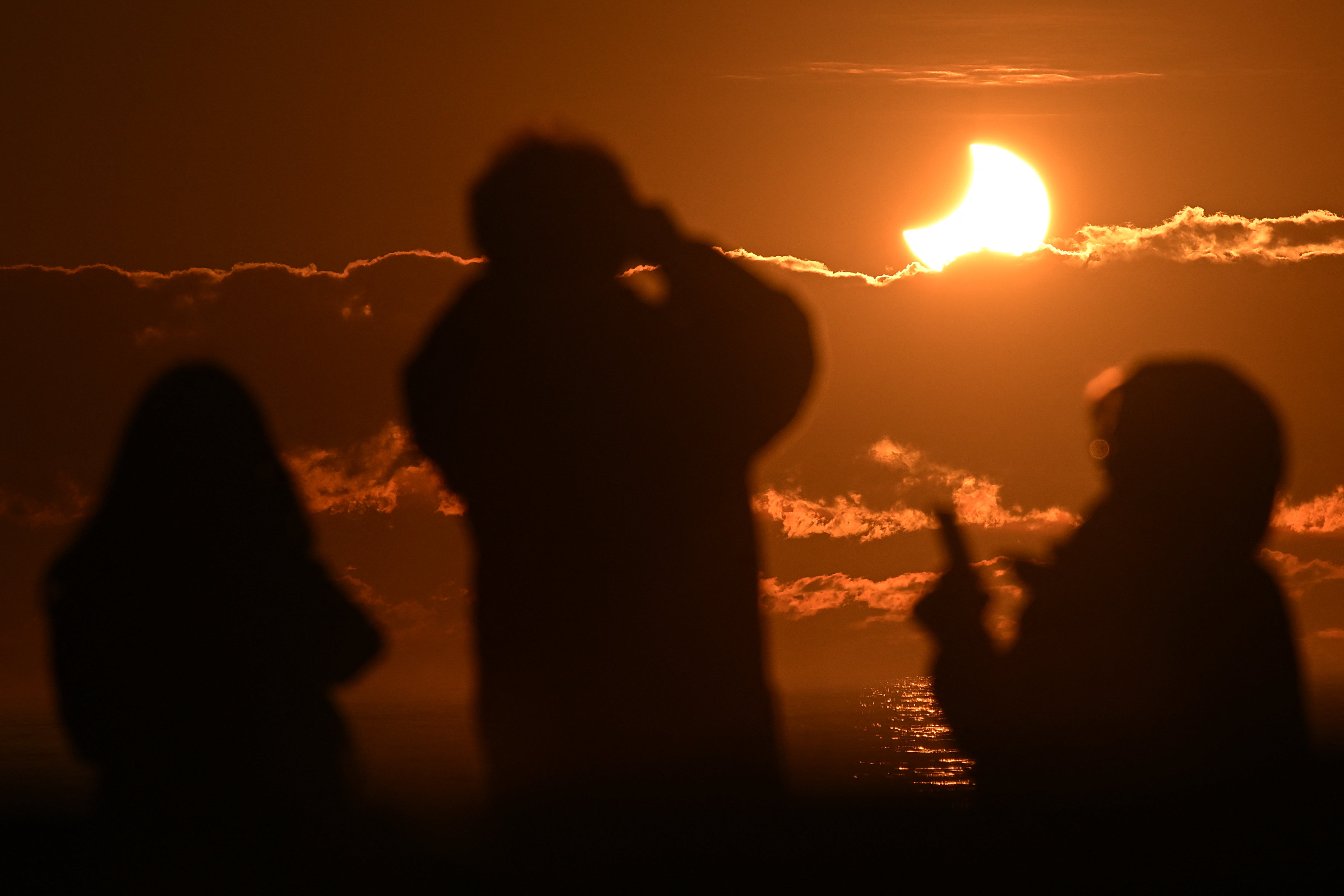 Los expertos advierten a la gente que solo debe observar el eclipse con lentes especiales para eclipses o utilizando un visor de agujero de alfiler o un proyector de agujero de alfiler, como un colador