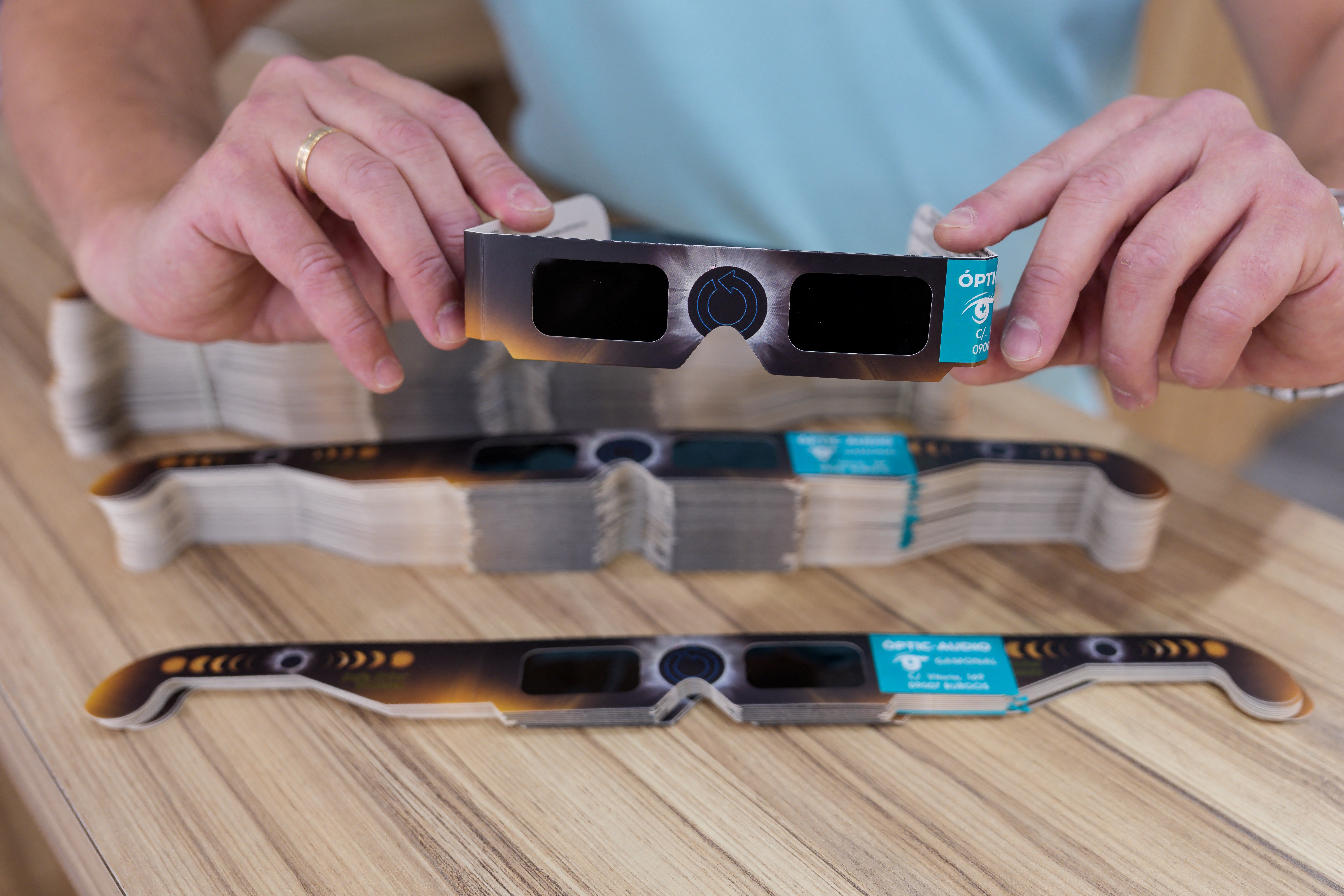 Un hombre sostiene unos lentes para observar el eclipse que cuentan con la certificación de la norma internacional de seguridad ISO 12312-2:2015