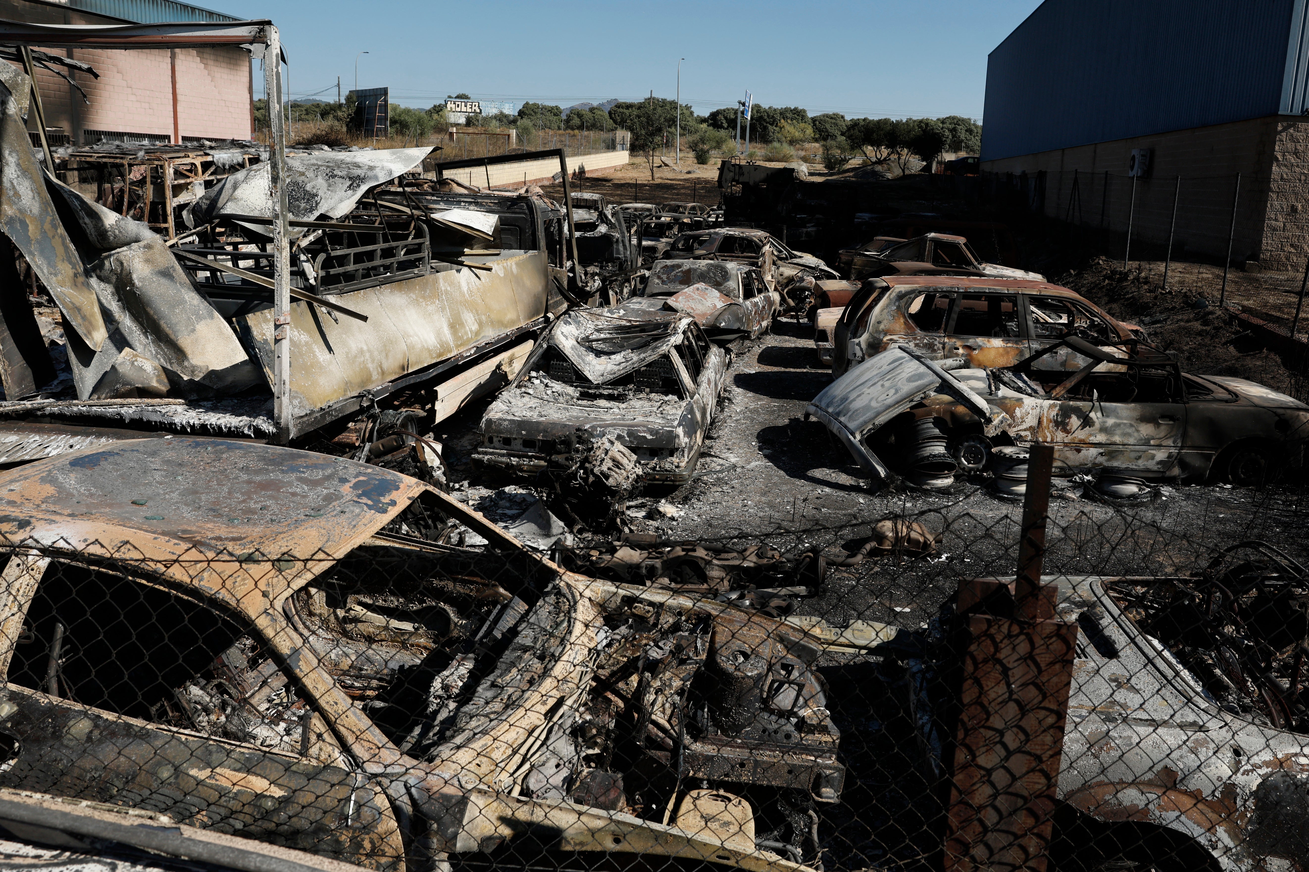 Se ven vehículos calcinados en un polígono industrial tras un incendio forestal en Chapinería, España