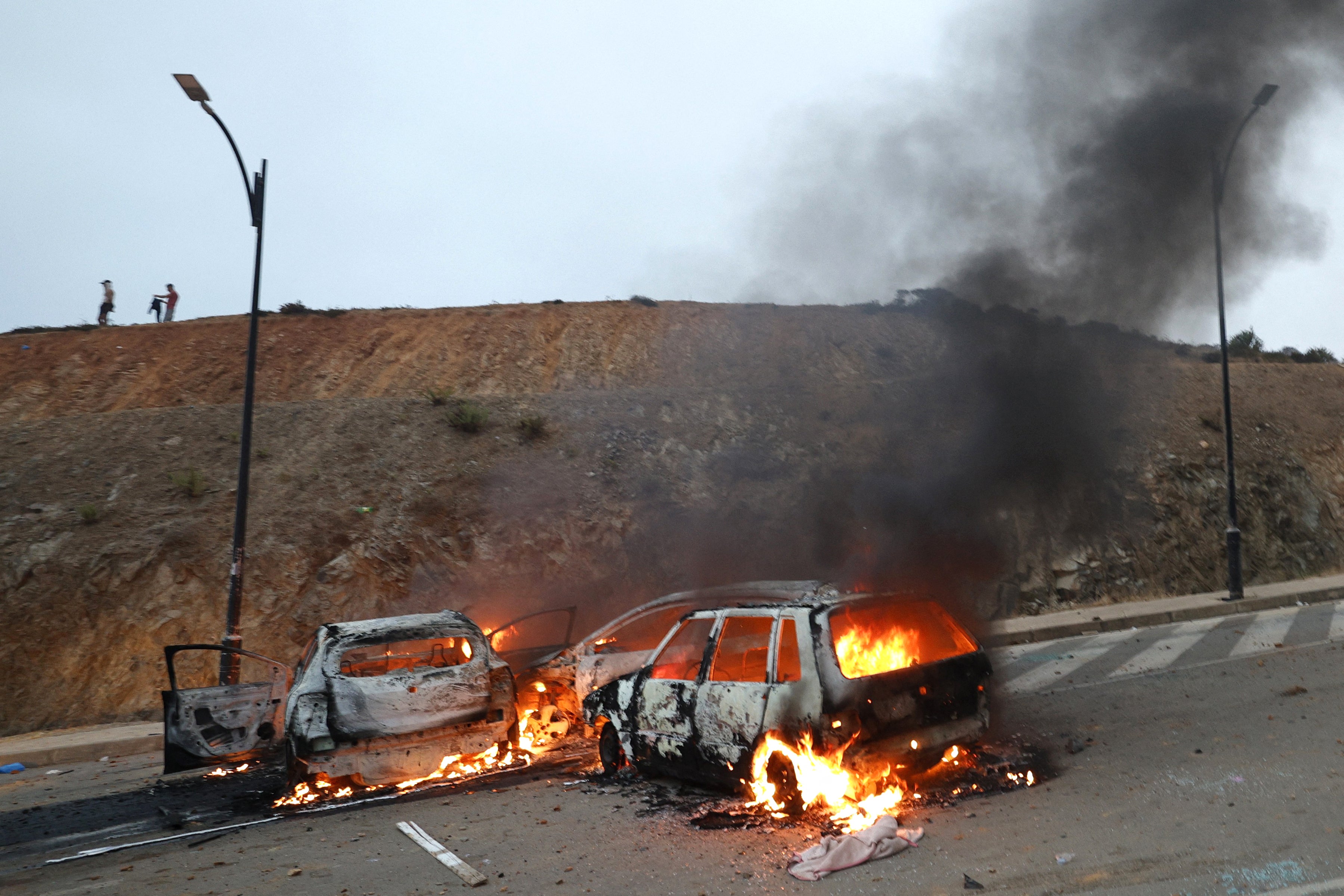 Varios vehículos arden en el lugar de los enfrentamientos cerca de Fnideq, en la frontera entre Marruecos y España