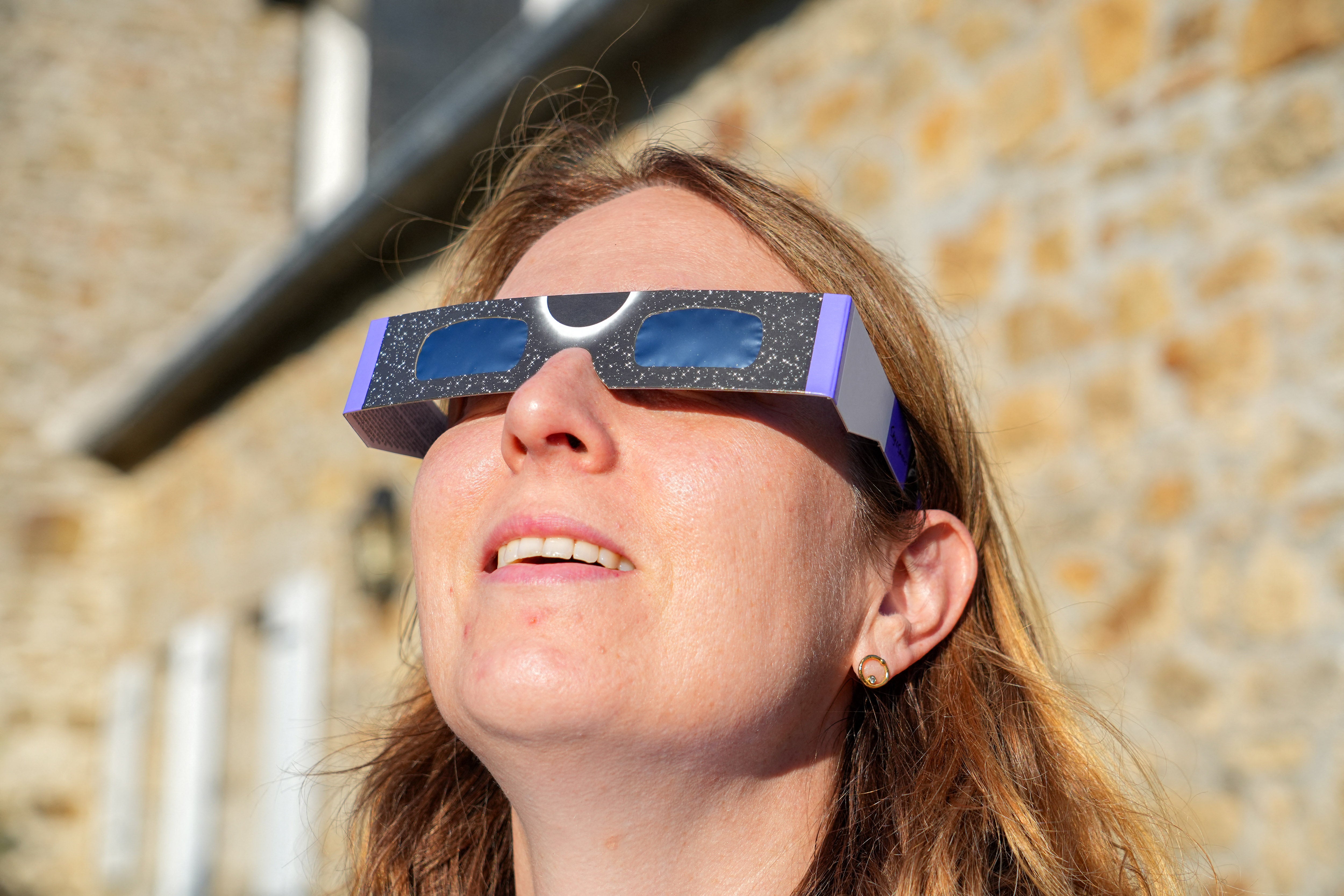 Una mujer observa el sol a través de unas gafas especiales de cartón diseñadas para protegerle los ojos mientras contempla el eclipse solar del 12 de agosto en Saint-Pol-de-Léon, en el departamento de Finisterre, en Bretaña (oeste de Francia), el 1 de agosto de 2026