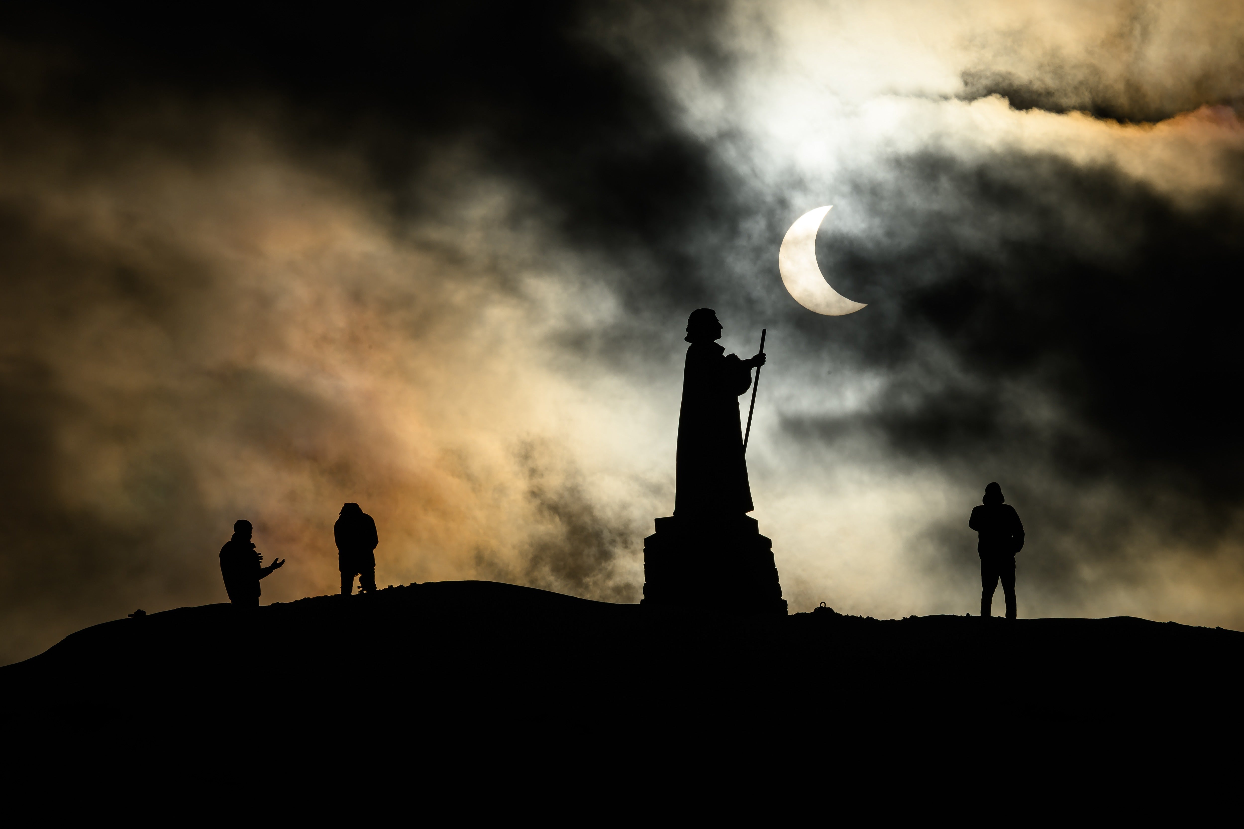 La estatua del misionero luterano dano-noruego Hans Egede se recorta contra el cielo durante un eclipse solar parcial el 29 de marzo de 2025 en Nuuk, Groenlandia
