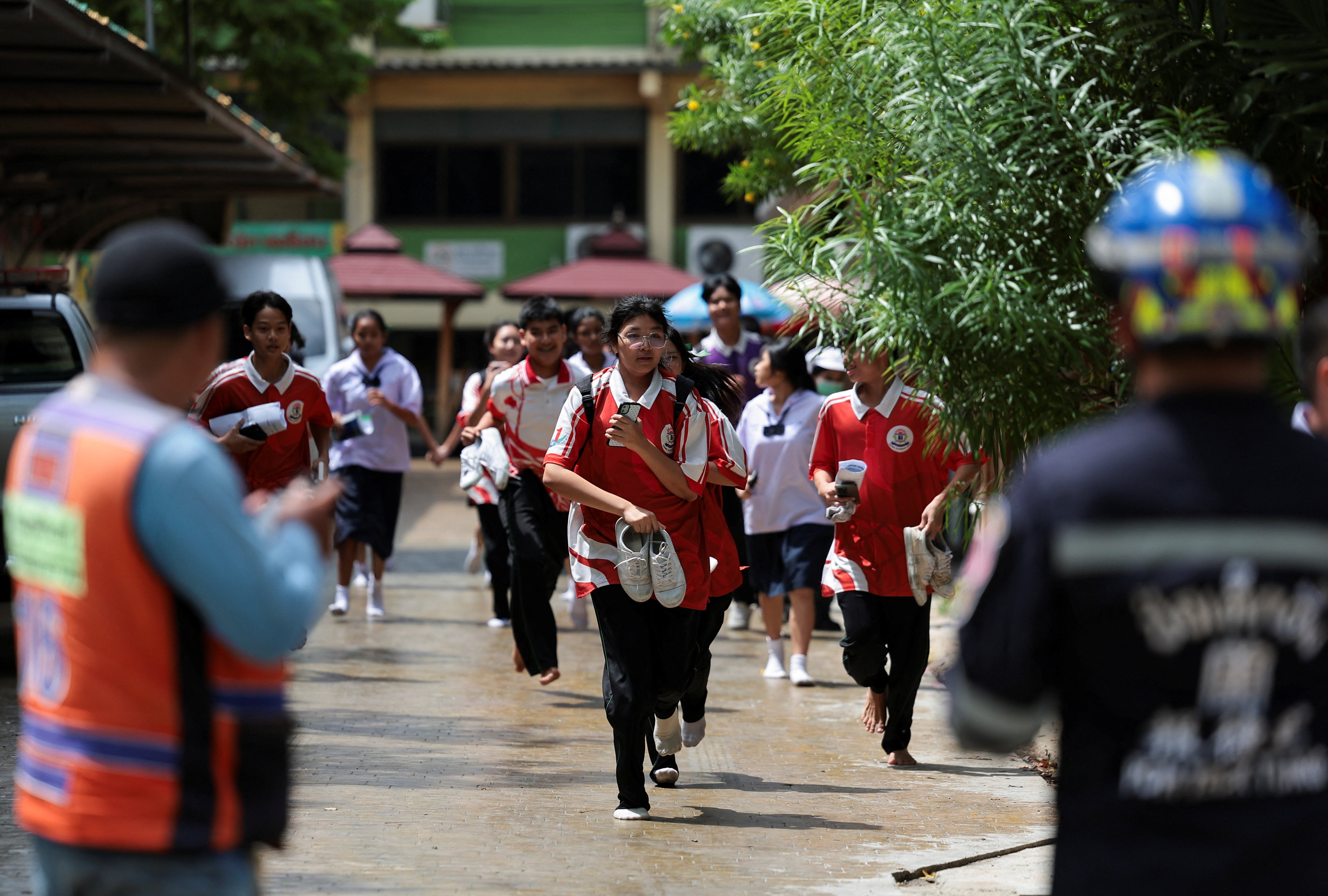 Los estudiantes corren mientras evacúan la escuela Debsirin Nonthaburi, donde ocurrió un tiroteo, en el distrito de Bang Kruai