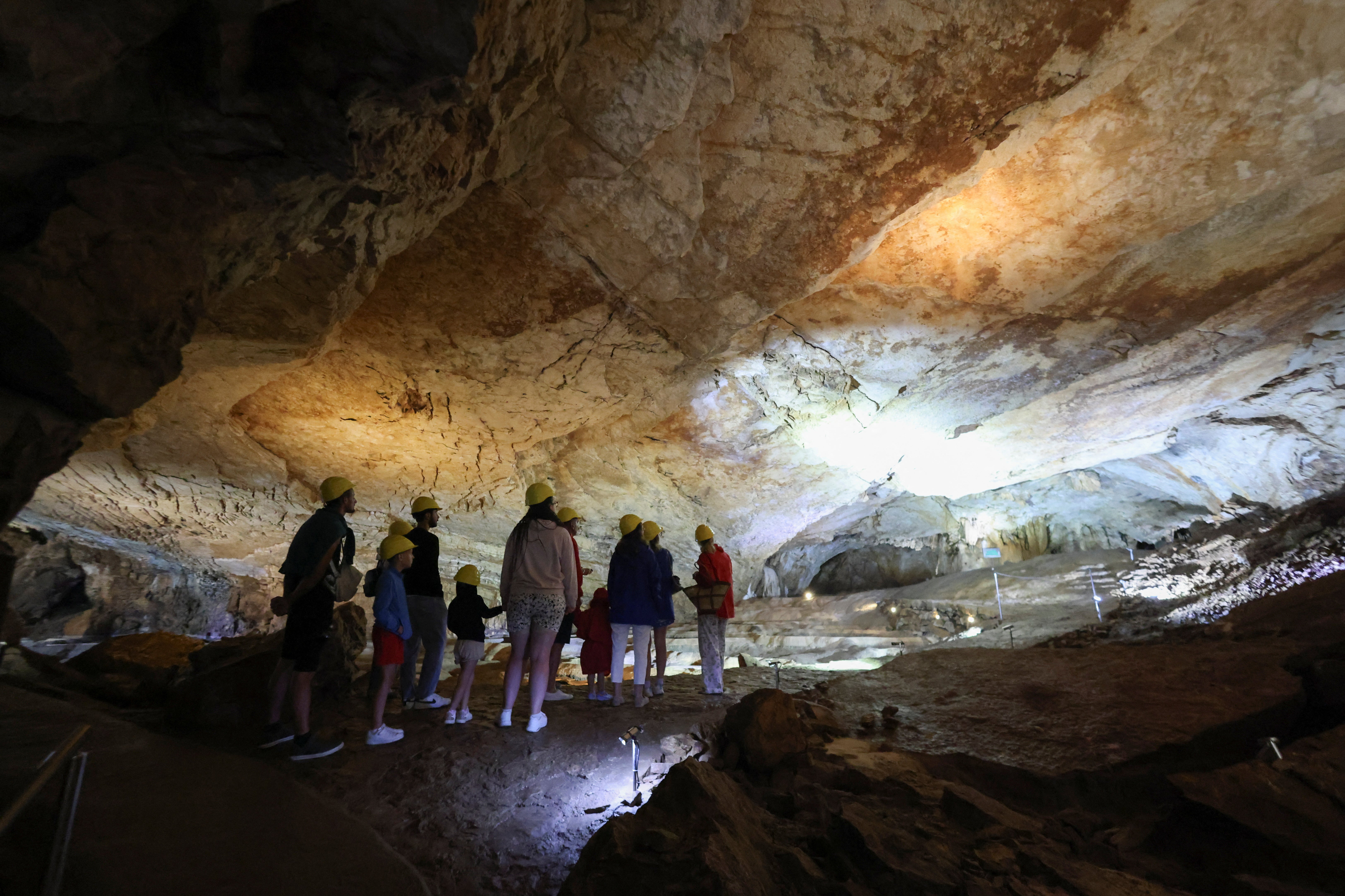 Turistas visitan la cueva de Vjetrenica, declarada Patrimonio de la Humanidad por la Unesco, donde la temperatura se mantiene en 11 °C durante todo el año y ofrece un refugio frente al calor del verano