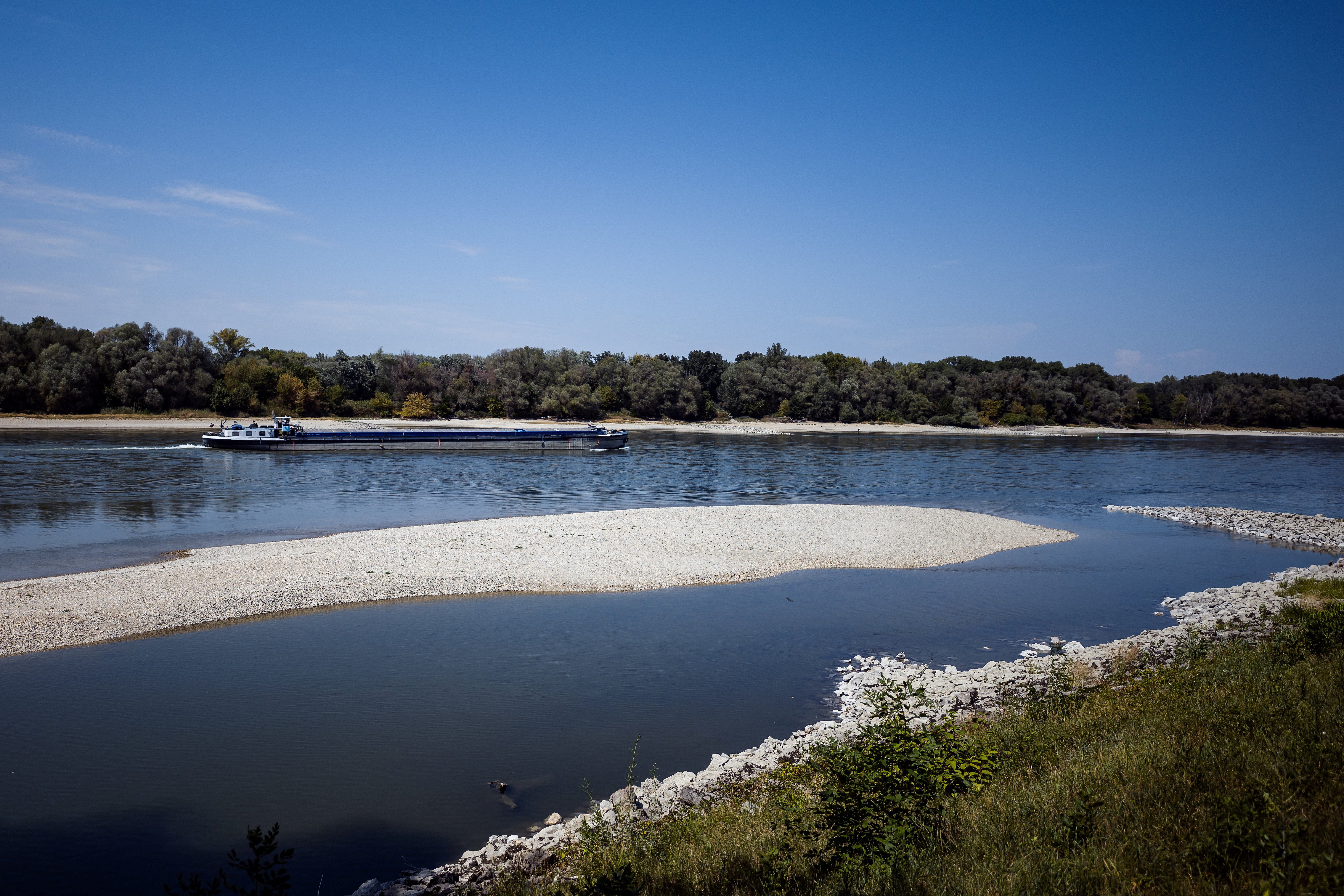 Una embarcación avanza por el río Danubio, cuyo caudal alcanzó niveles históricamente bajos durante la ola de calor, cerca de Bad Deutsch-Altenburg, Austria