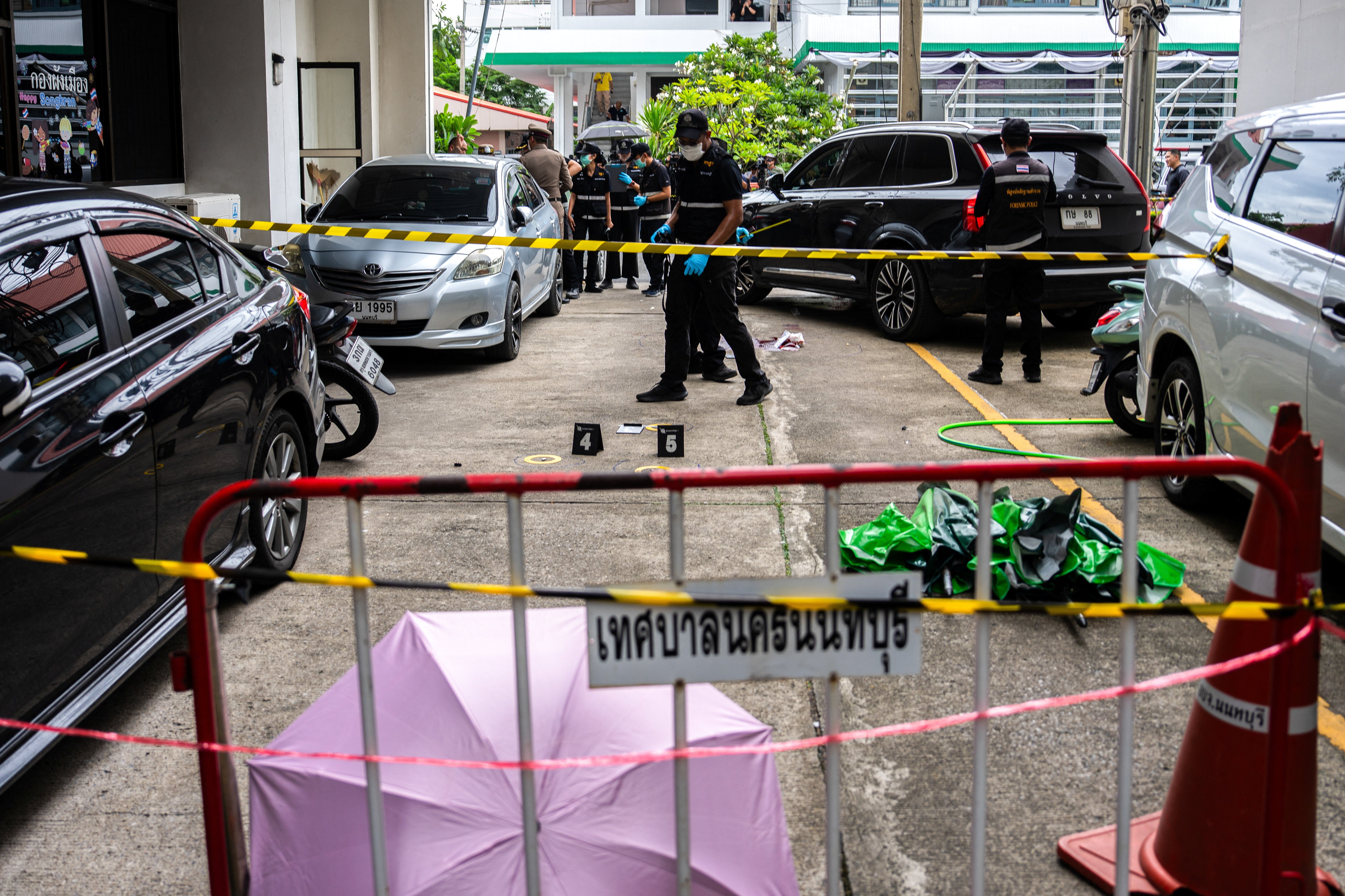 Agentes de la policía forense inspeccionan el lugar donde el exlegislador Chalong Riewrang presuntamente disparó contra Thongchai Yenprasert, presidente de la Organización Administrativa Provincial de Nonthaburi