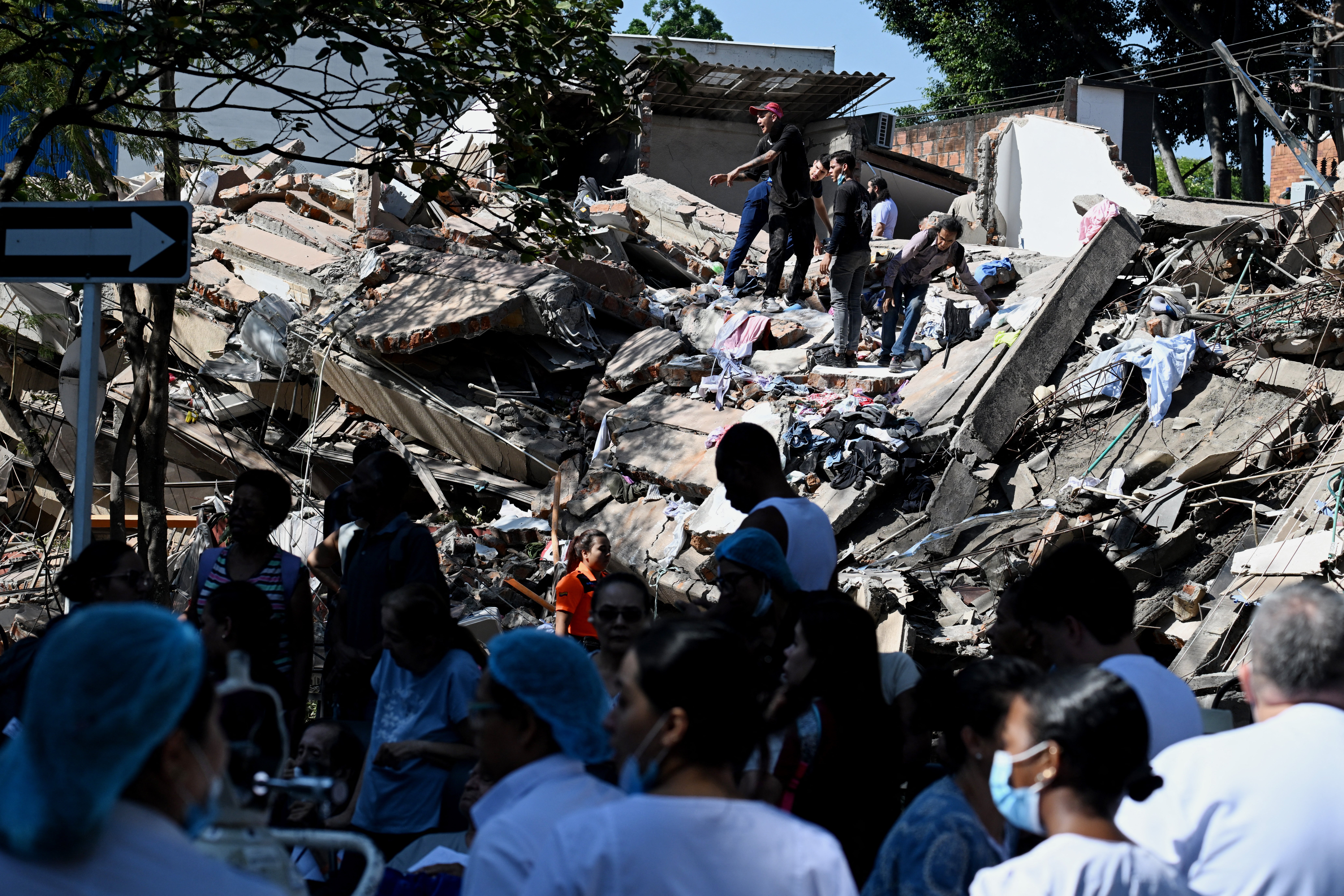 <p>Unas personas trabajan en un edificio derrumbado tras un terremoto en Cali, Colombia</p>