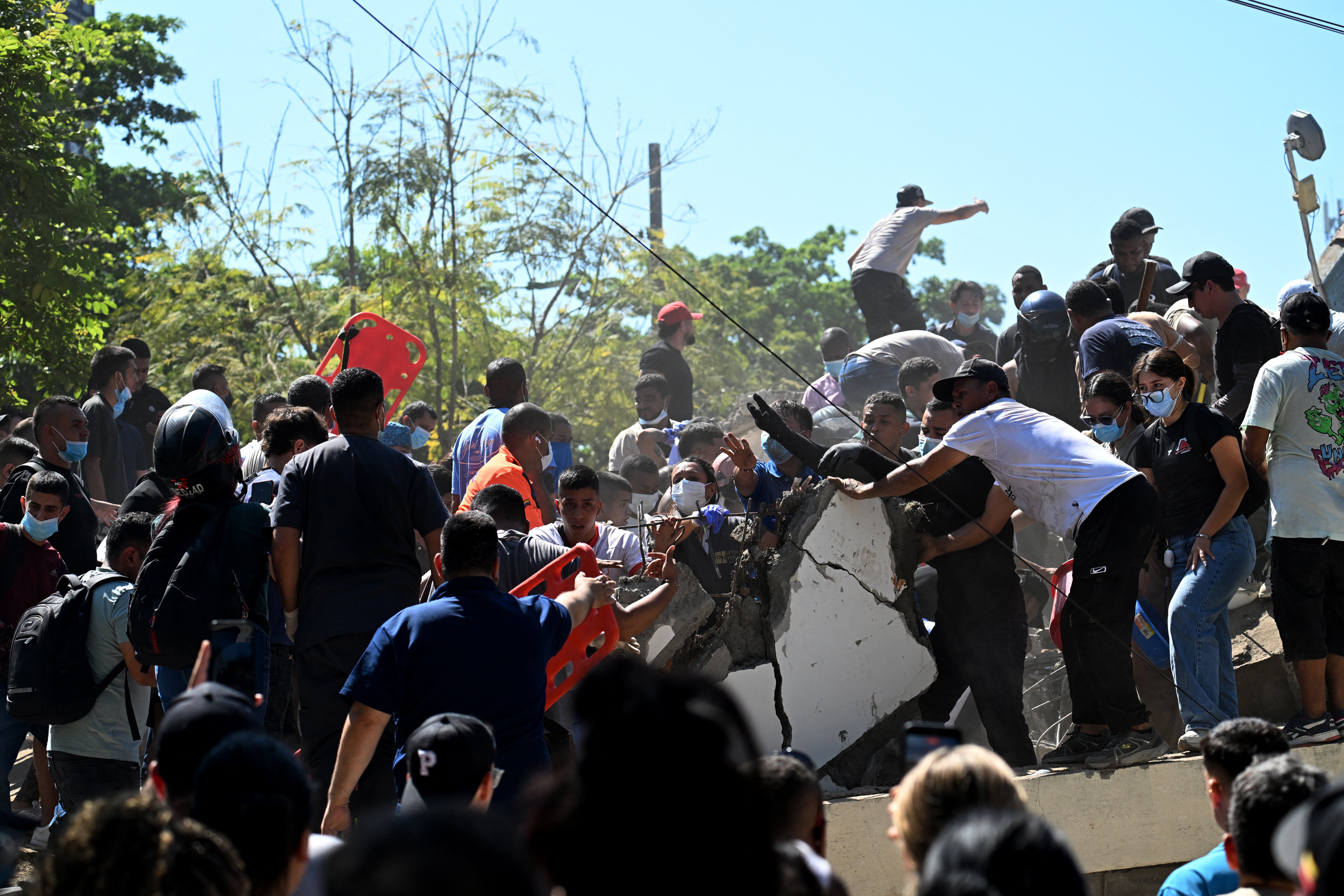 La gente busca supervivientes entre los escombros de un edificio derrumbado tras un terremoto en Cali, Colombia