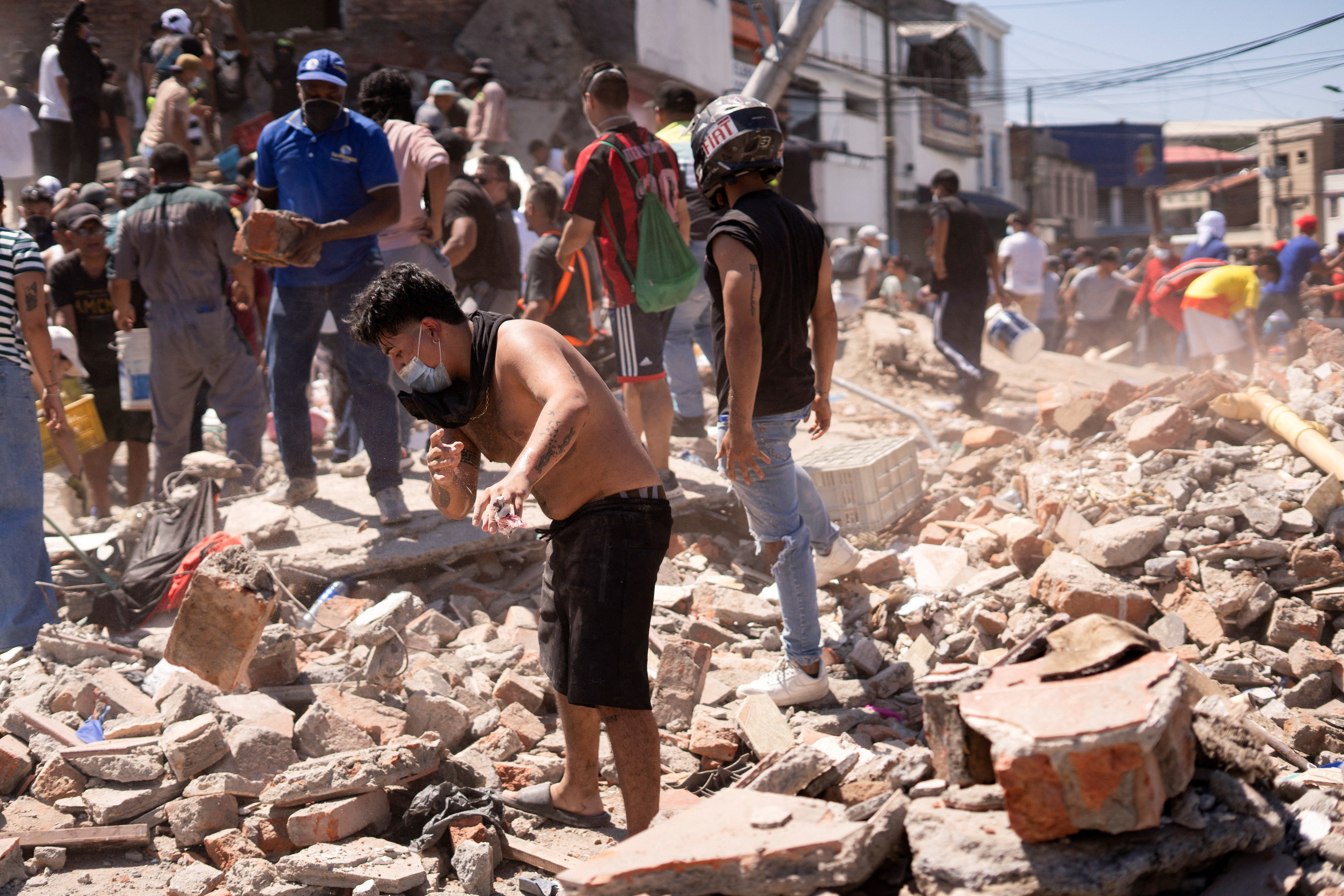 Los vecinos rebuscan entre los escombros de un edificio derrumbado tras un terremoto, en Cali, este lunes