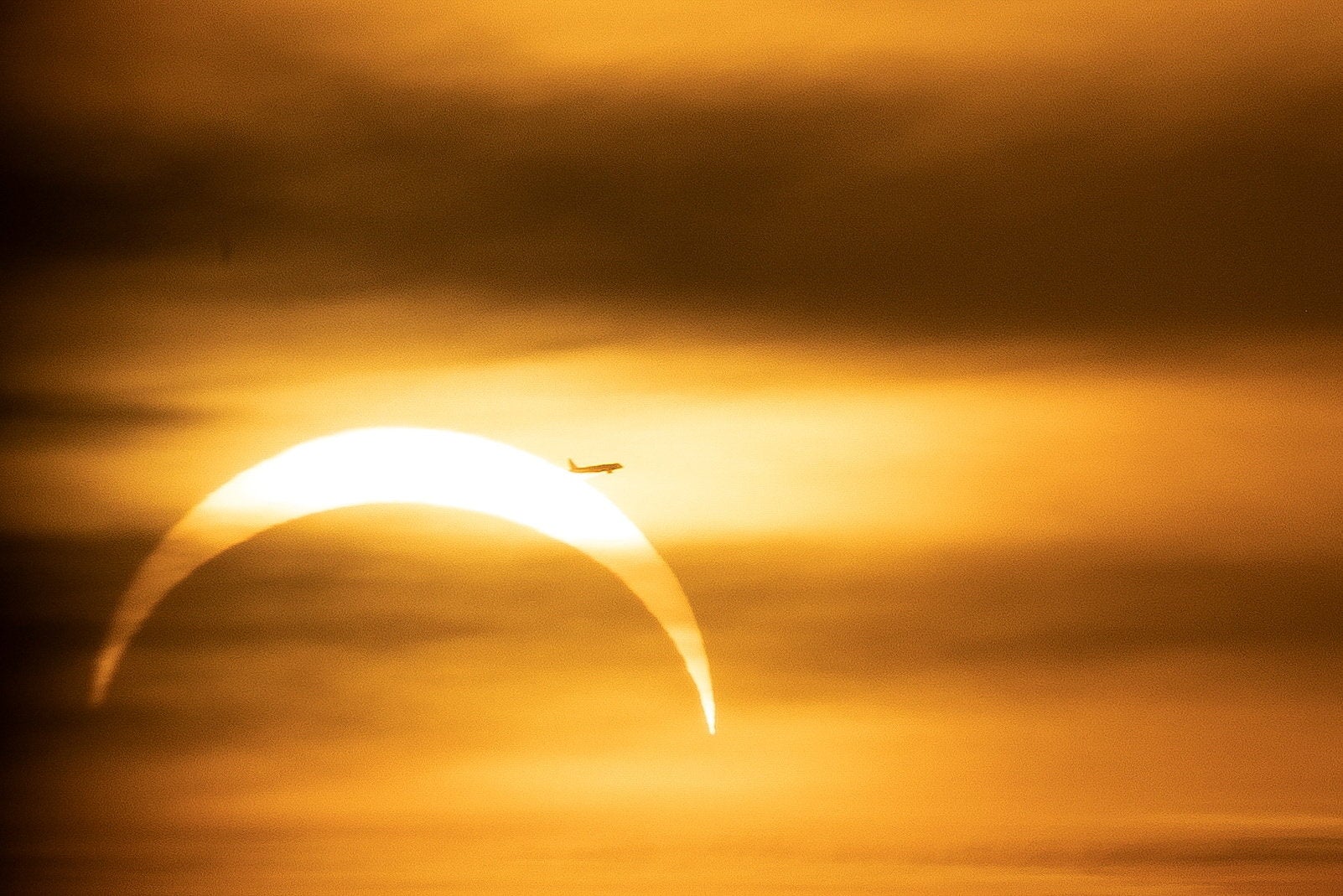 Un avión pasa frente al Sol mientras la Luna lo cubre de forma parcial durante un eclipse solar visto desde Praga, República Checa, el 12 de agosto de 2026