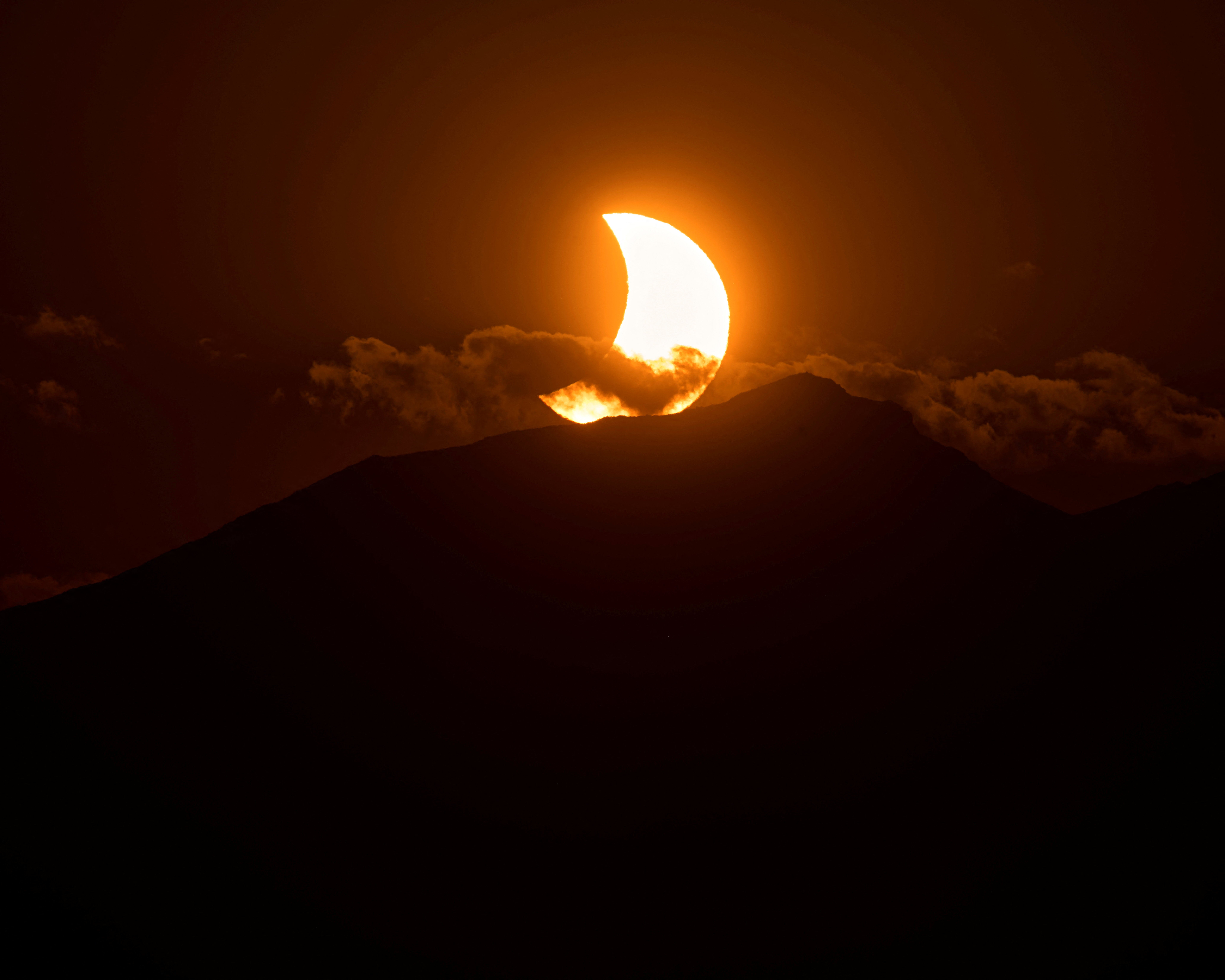 La Luna cubre parte del Sol durante el eclipse solar sobre las montañas cercanas a la localidad de Reinosa, en el norte de España, el 12 de agosto de 2026