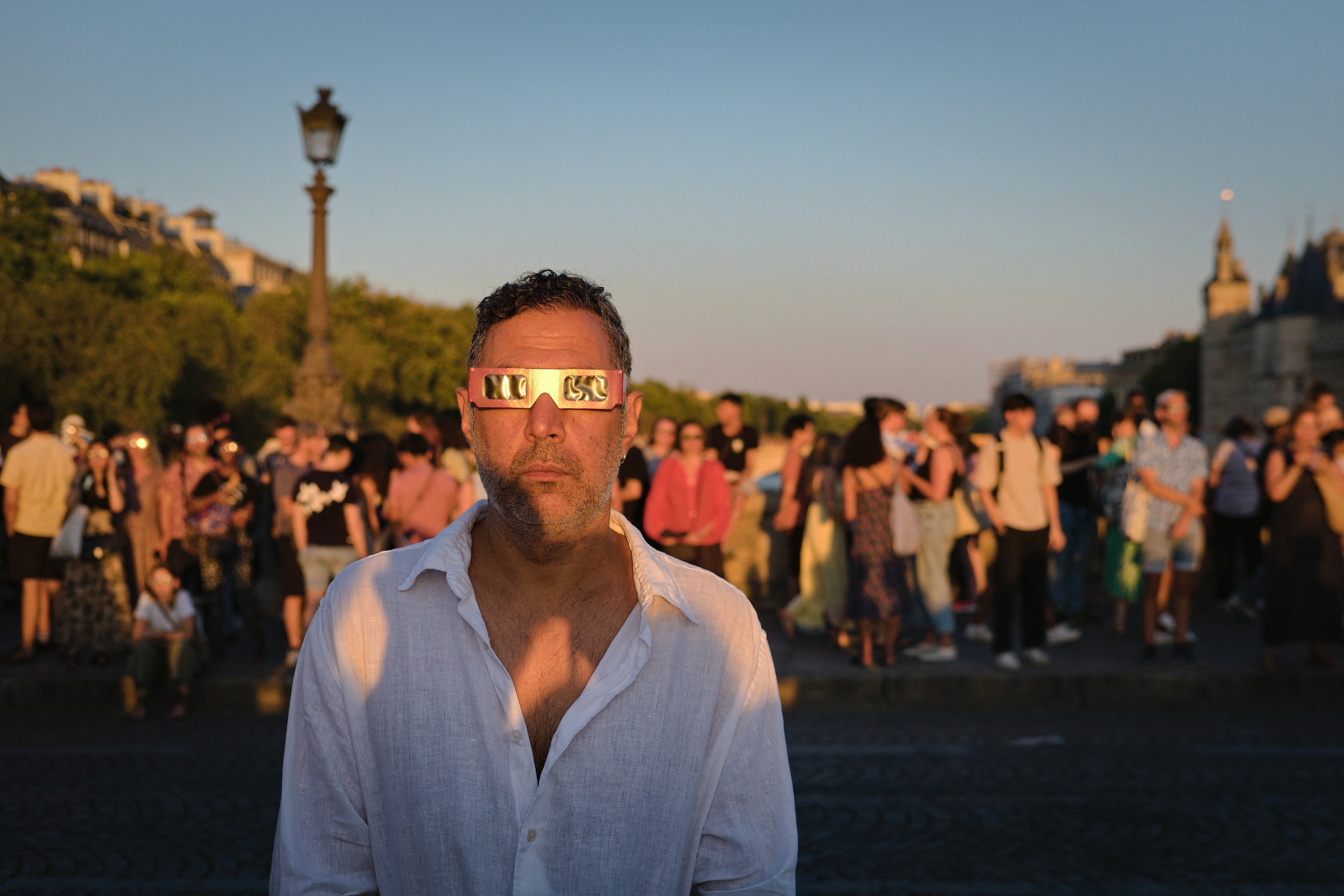 Personas con lentes de protección observan el eclipse solar desde el Pont Neuf, en París, Francia, el 12 de agosto de 2026