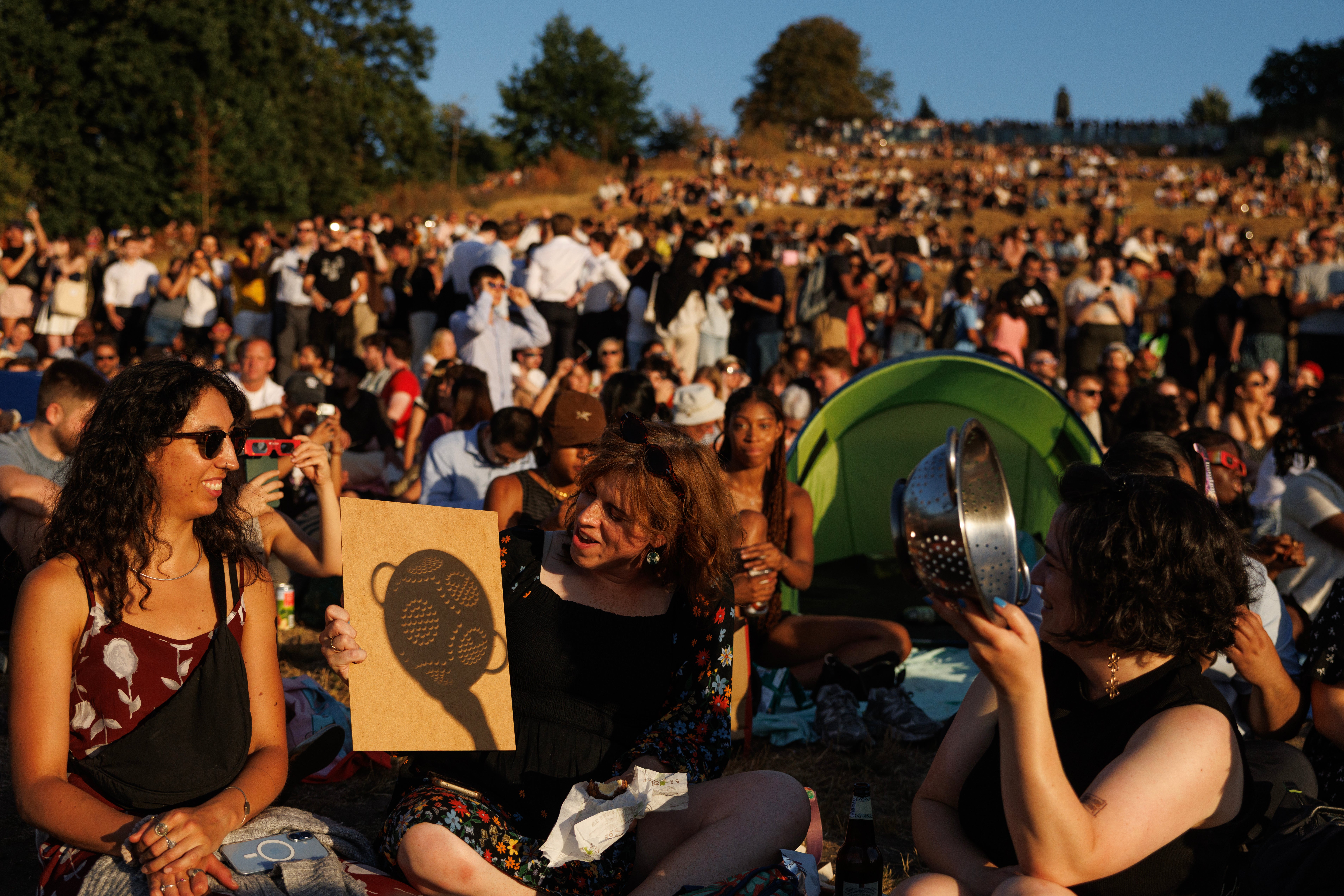 La gente se reúne para contemplar el eclipse solar parcial en Greenwich Park