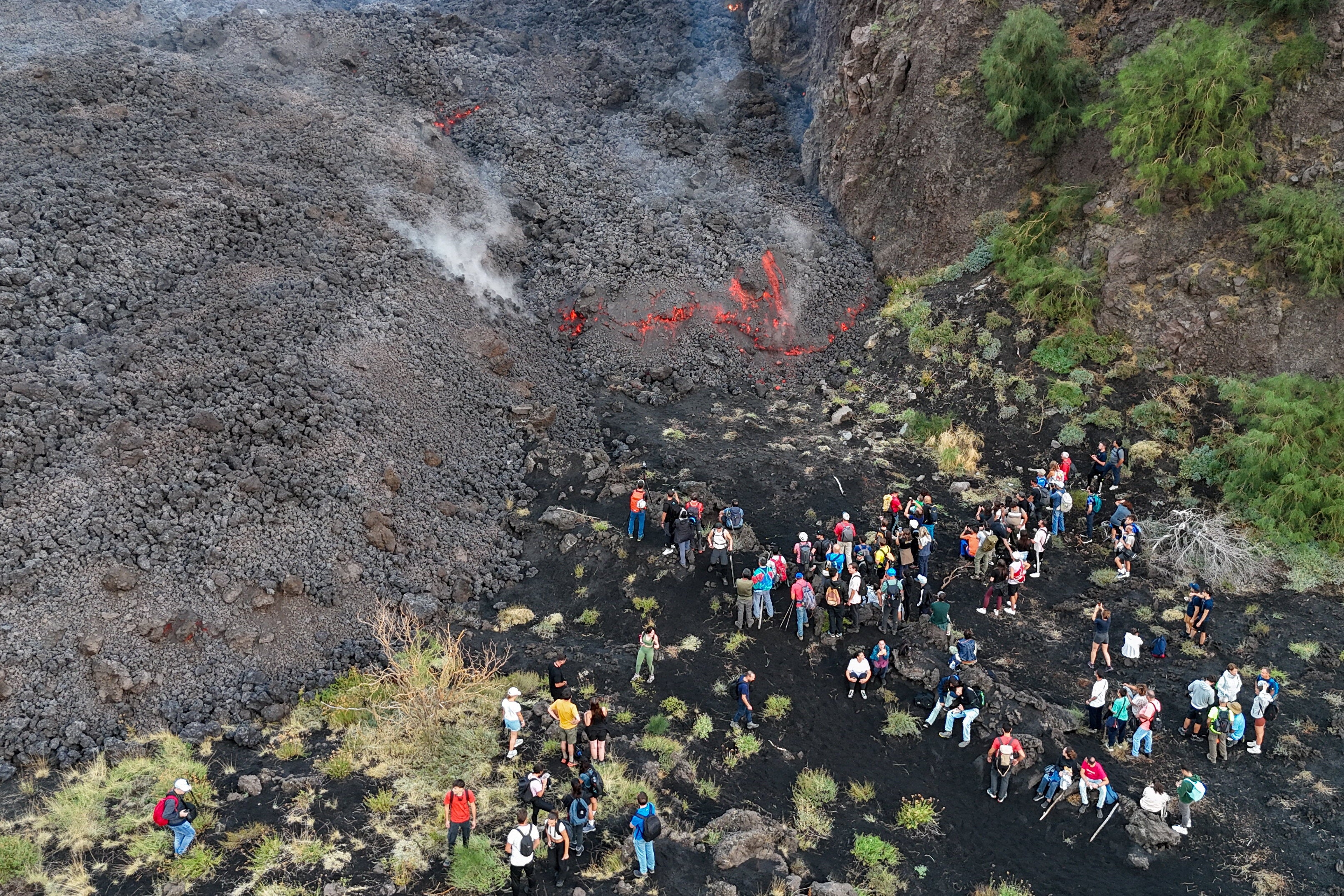 Imagen tomada desde un dron de personas que observan una erupción volcánica en el Monte Etna