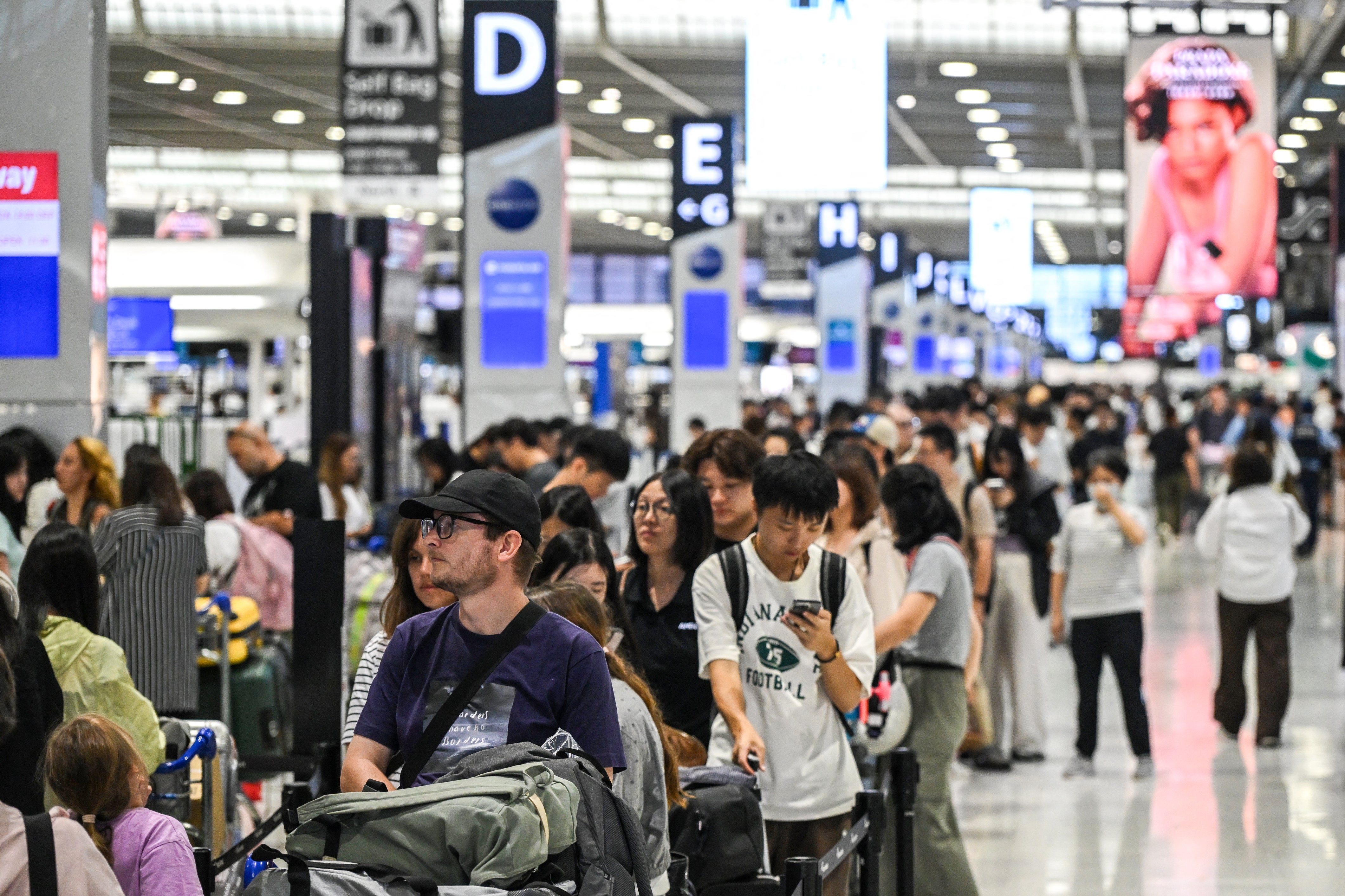 La gente hace cola delante del mostrador de facturación del aeropuerto de Narita