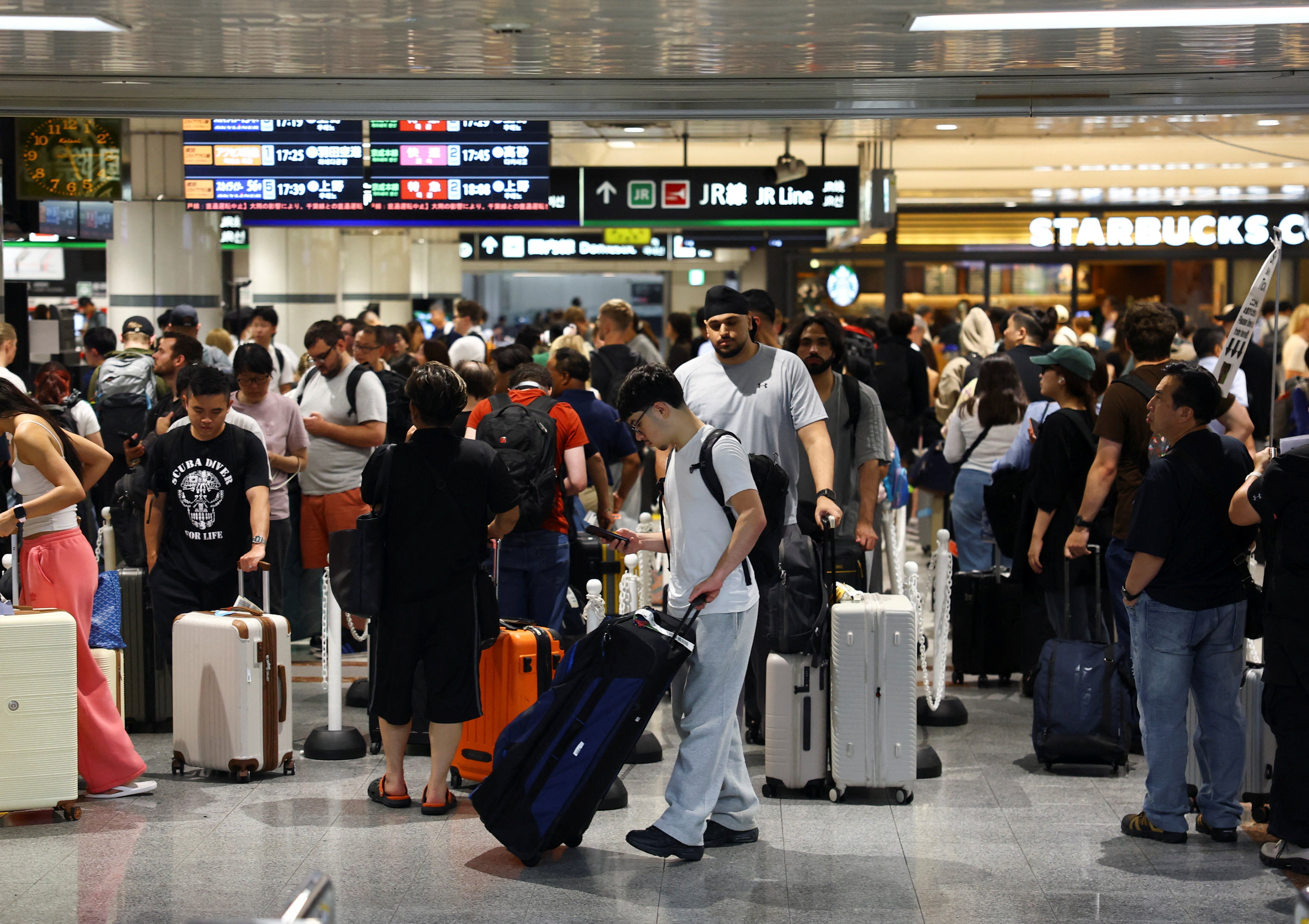 Los pasajeros hacen cola en una estación de tren del Aeropuerto Internacional de Narita, en Chiba, Japón