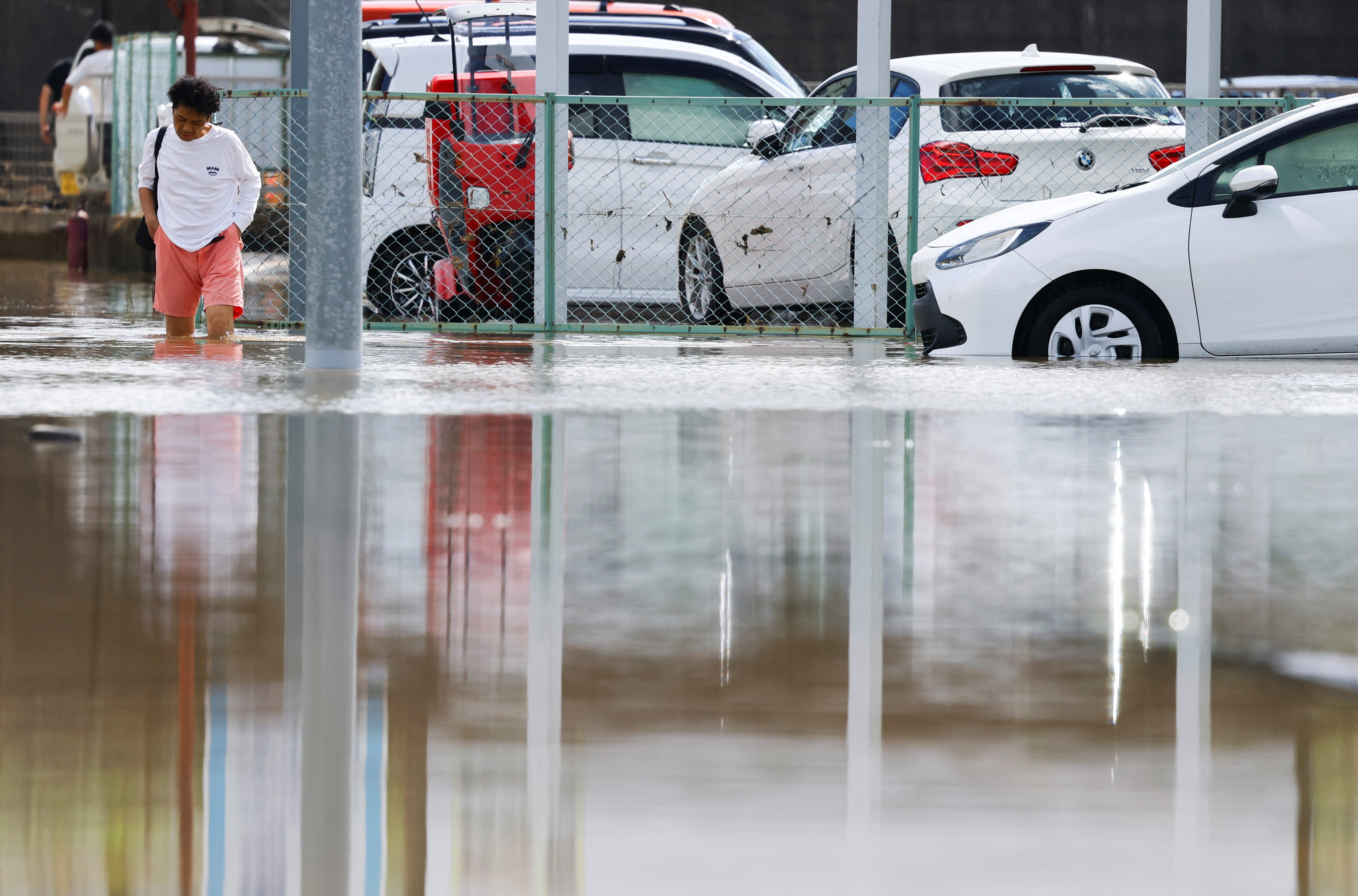 Un vecino camina por una zona inundada tras las fuertes lluvias caídas en Oamishirasato