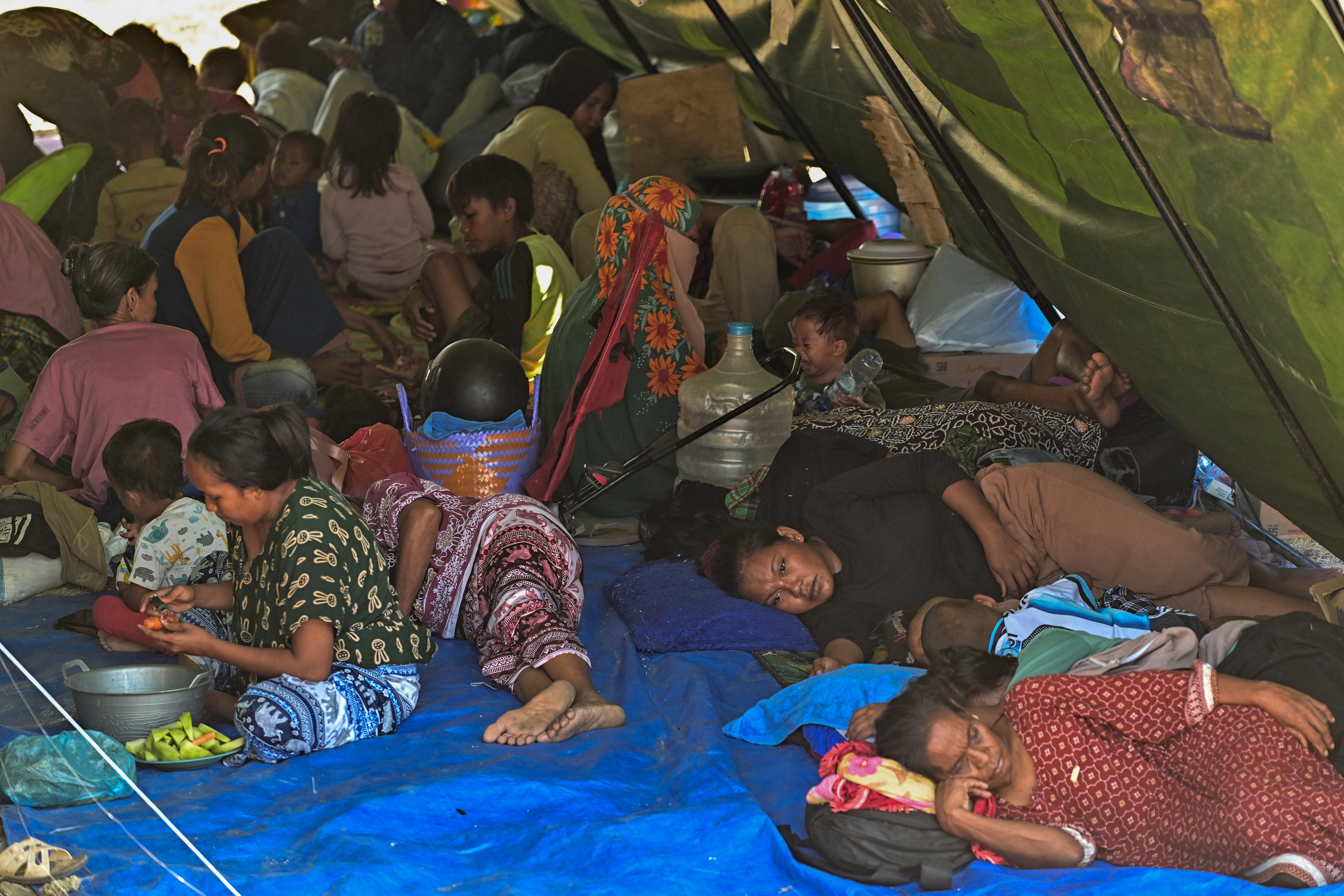 Los habitantes del pueblo descansan en una tienda de campaña en un campo abierto en Marapokot, Nagekeo, Nusa Tenggara Oriental