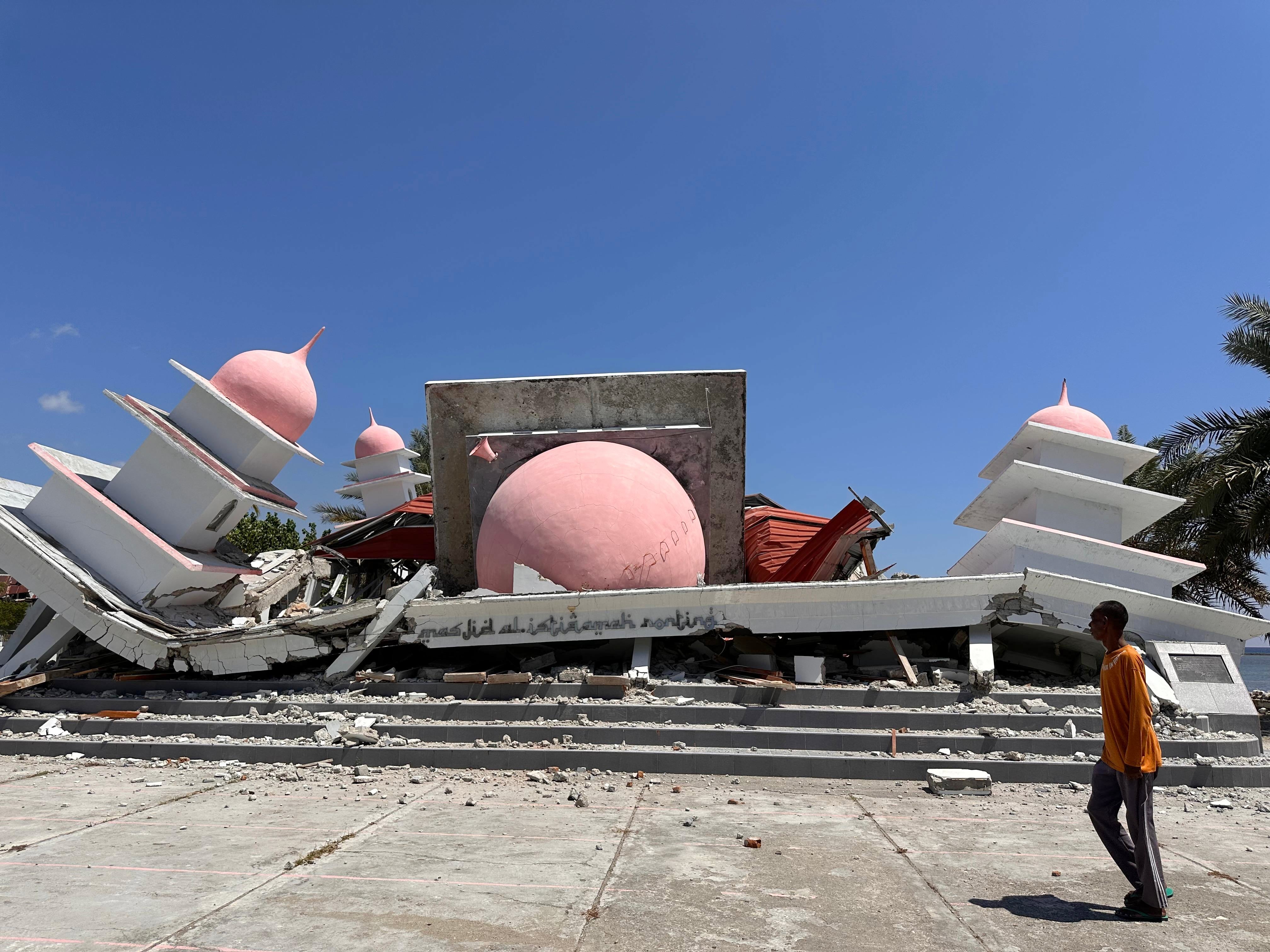 Un hombre camina frente a una mezquita que colapsó tras un terremoto en Lamba Leda, Indonesia, el martes. El sismo desplazó a decenas de miles de personas