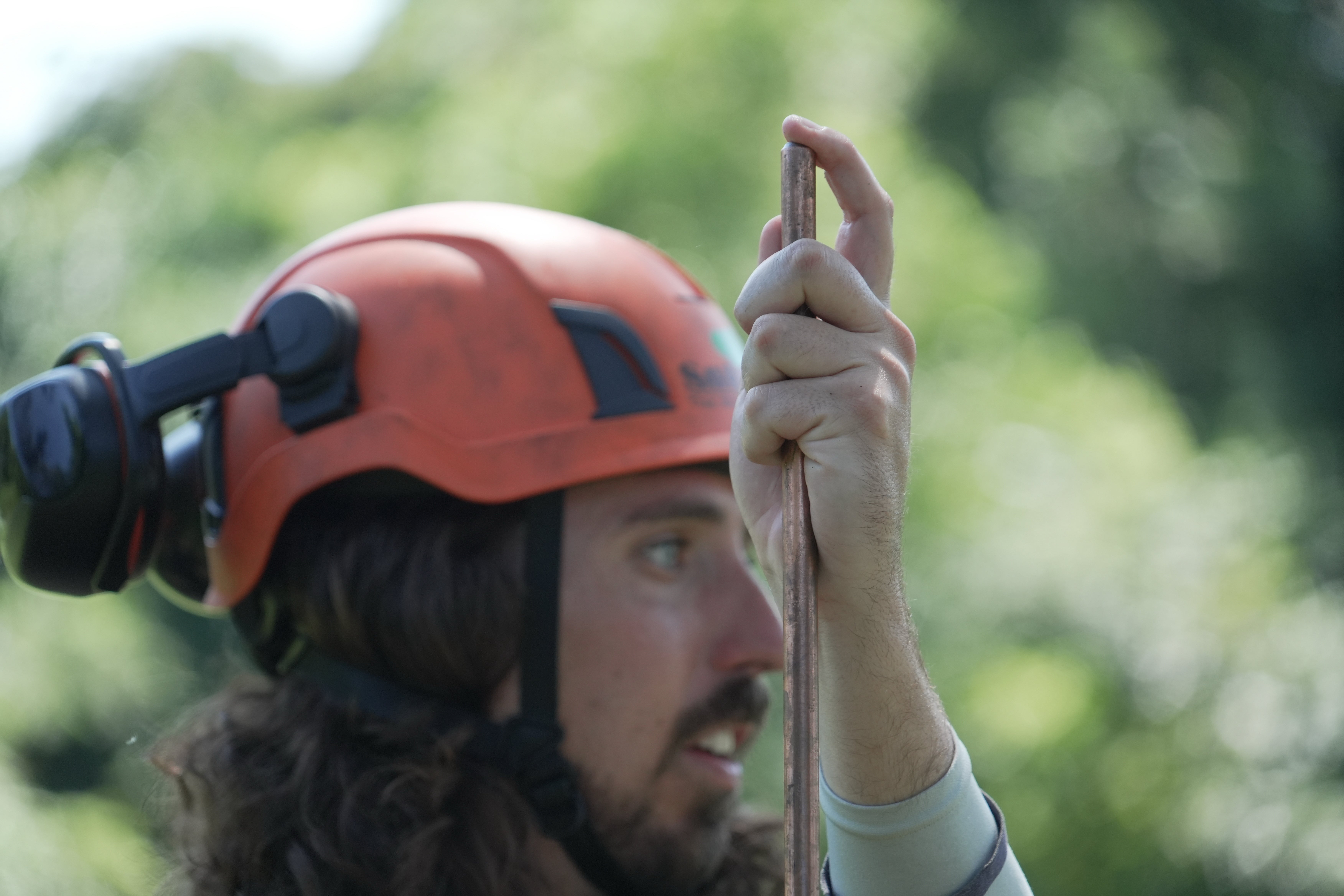 Jake Love, arborista de SavATree, sostiene un pararrayos de cobre junto al árbol