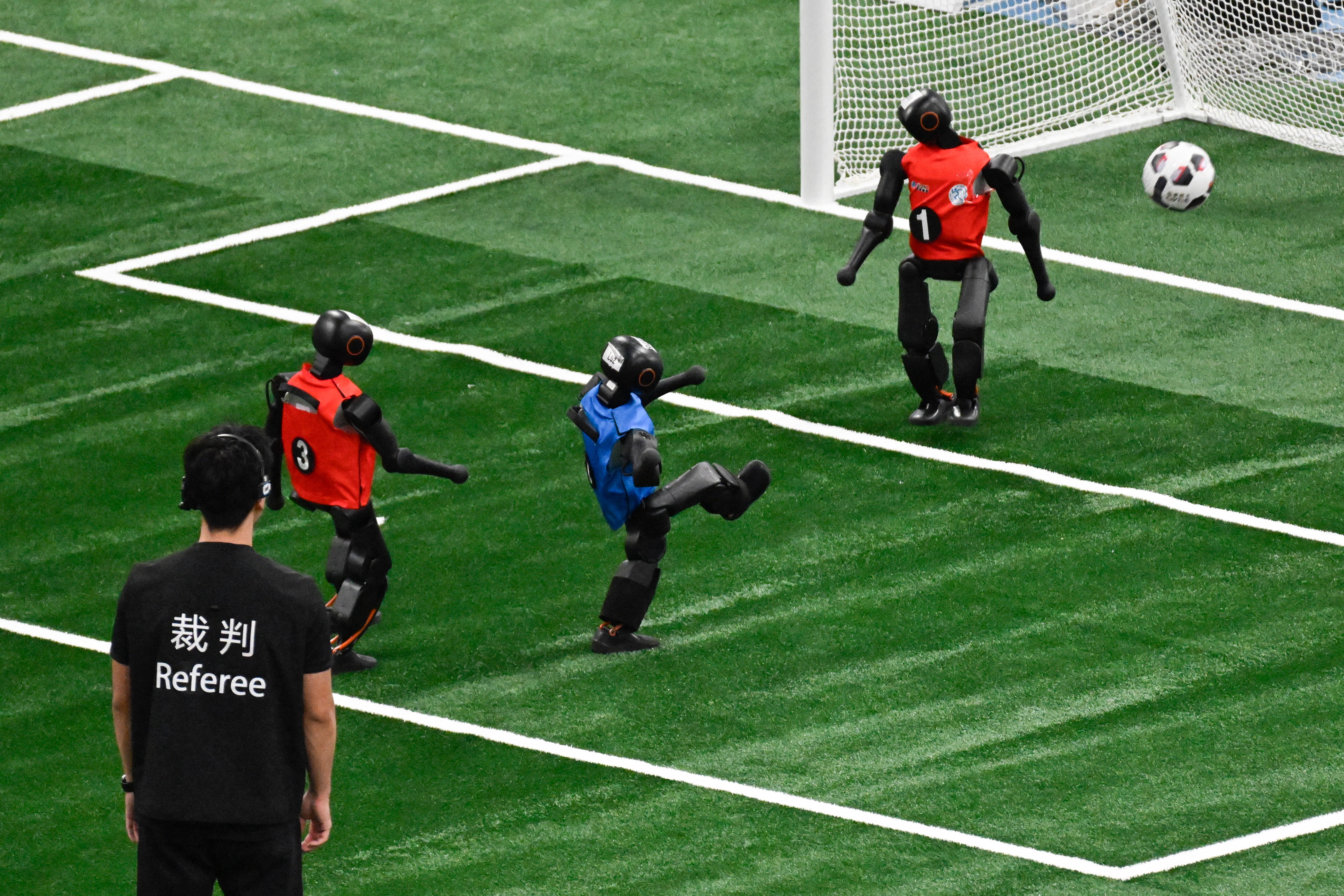 Un robot humanoide patea una pelota durante un partido de fútbol en la 2.ª edición de los Juegos Mundiales de Robots Humanoides
