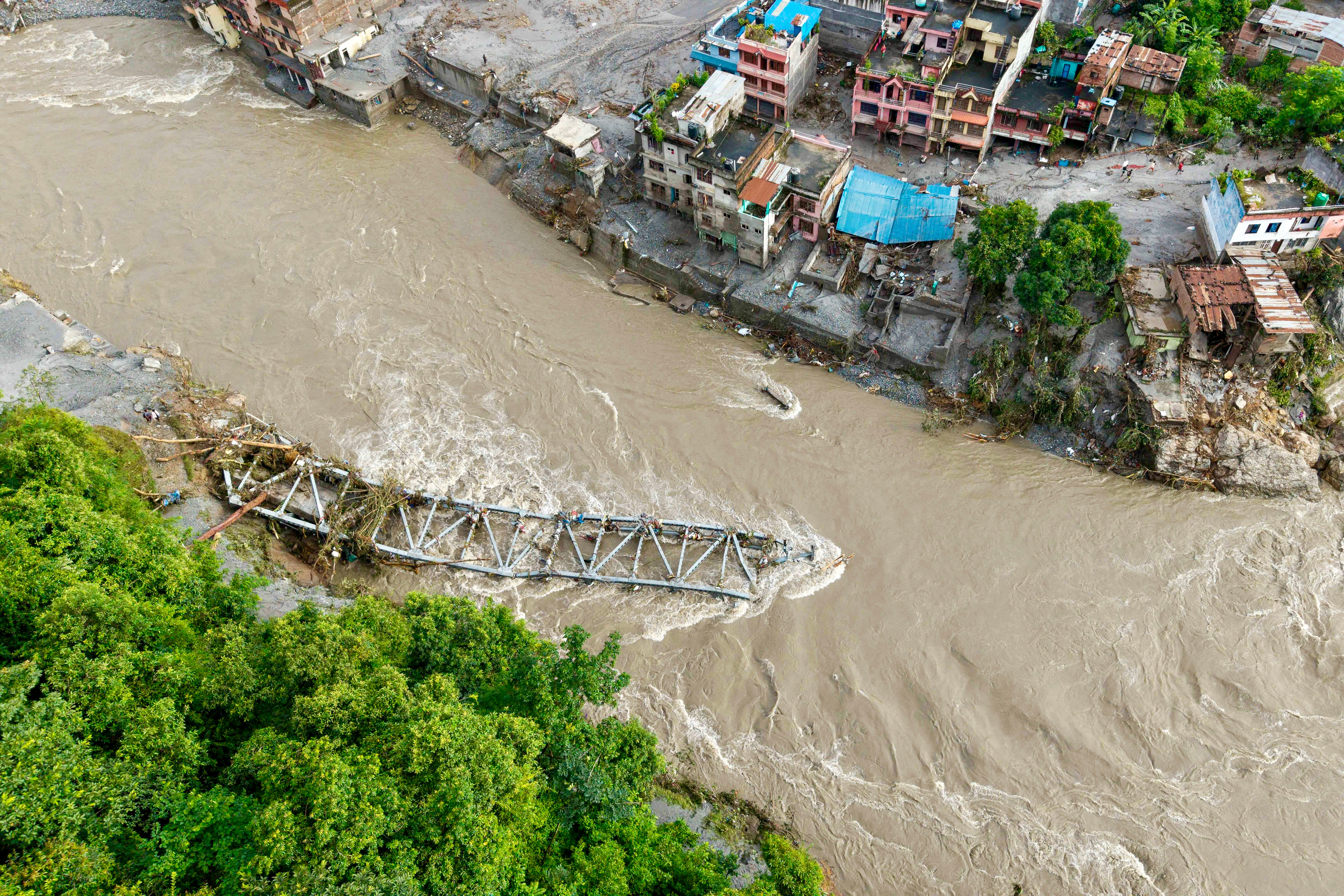 Un puente colapsado y viviendas cubiertas de lodo tras las inundaciones repentinas en Devighat, municipio de Bidur, en el distrito de Nuwakot, Nepal, el 27 de agosto de 2026