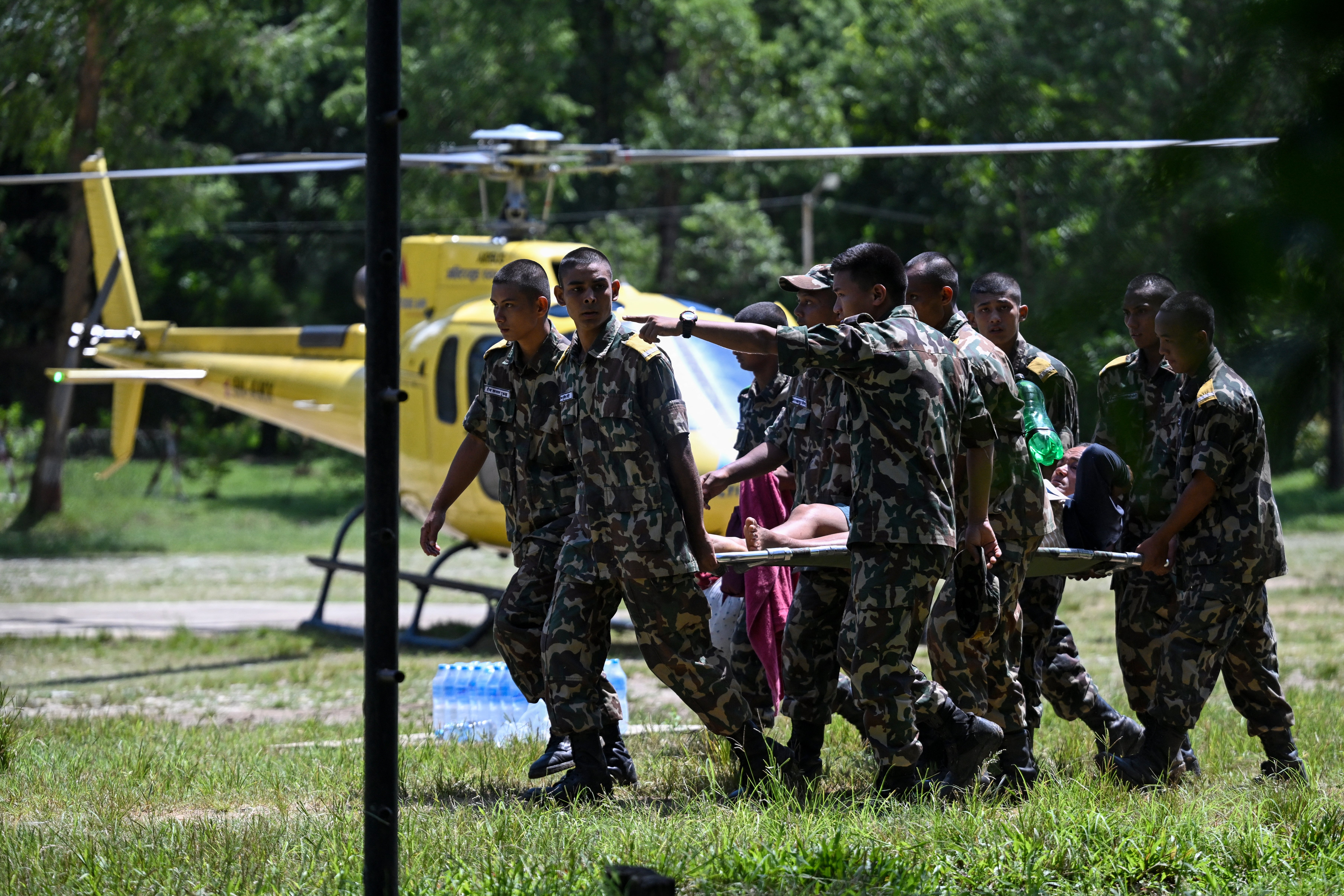 Miembros del ejército rescatan a residentes afectados por las inundaciones con un helicóptero tras unas crecidas repentinas, al llegar a un campamento militar en la localidad de Battar Bazar, en el distrito de Nuwakot, Nepal