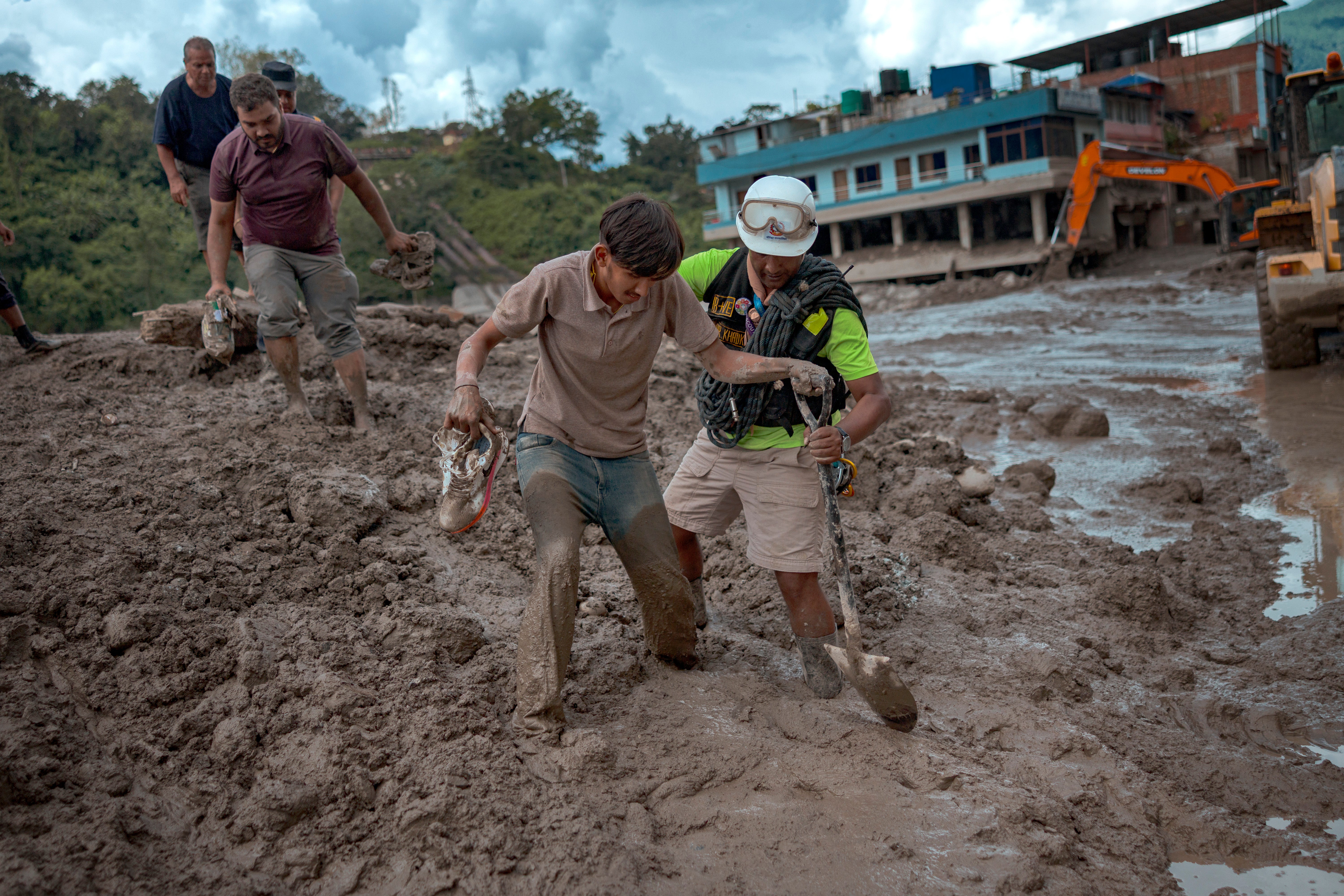 <p>Un rescatista ayuda a un sobreviviente tras las inundaciones repentinas en Trishuli, Nepal</p>