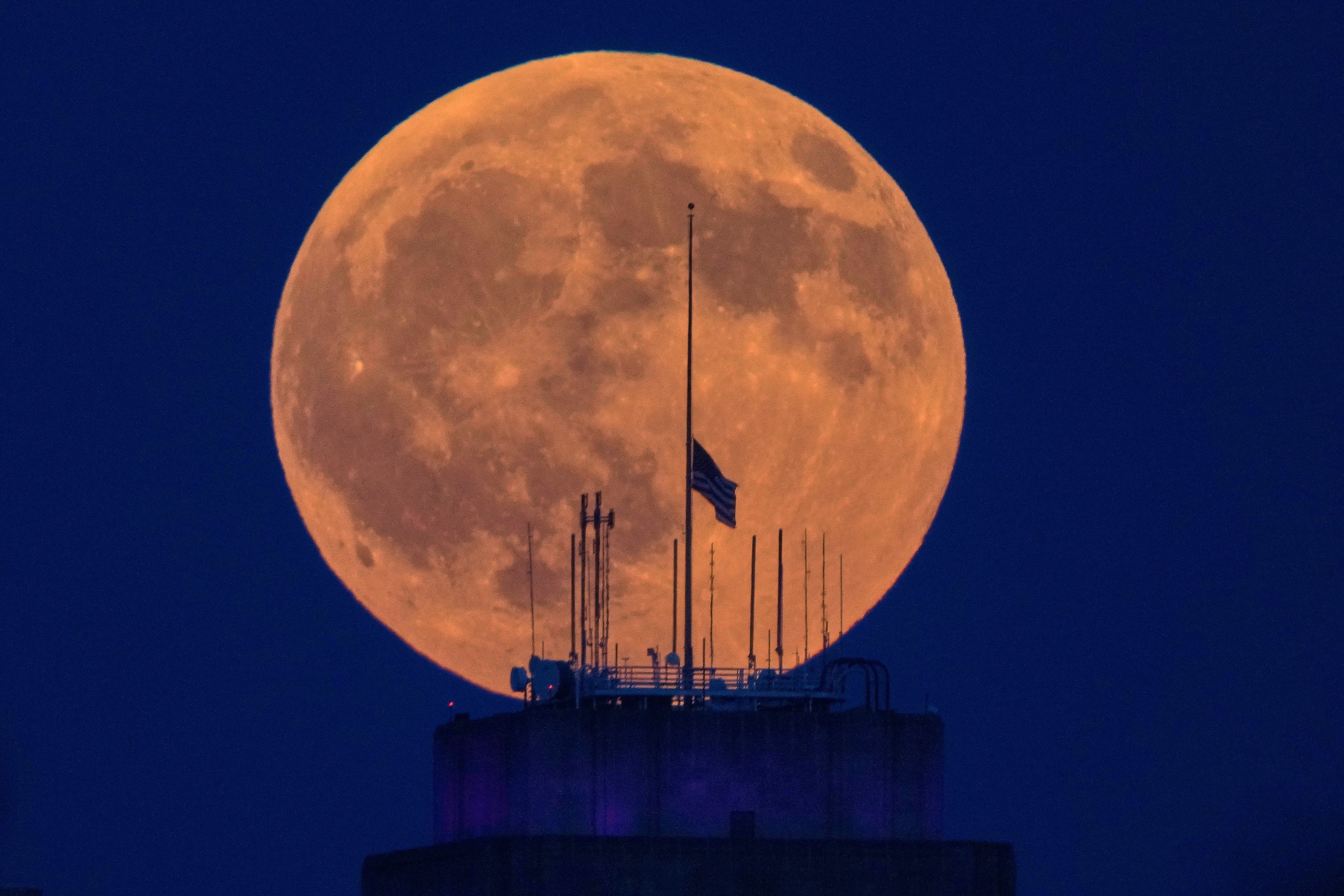 La luna llena sale por detrás del ayuntamiento, en el centro de Kansas City (Misuri), antes de un eclipse lunar
