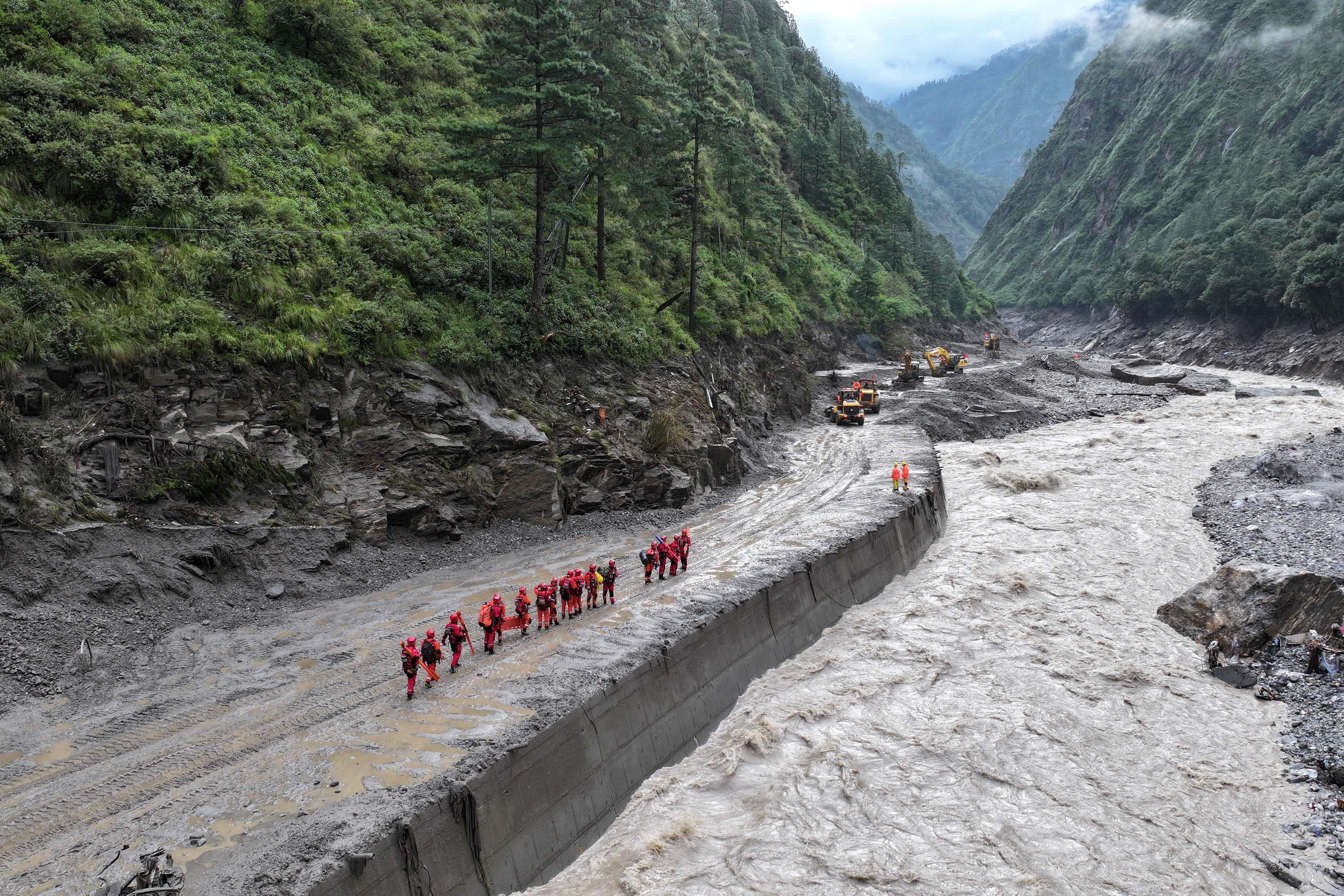 Bomberos durante una operación de búsqueda y rescate a lo largo de una carretera dañada que conduce al puerto de Gyirong, en la zona de Shigatse, en el Tíbet, China