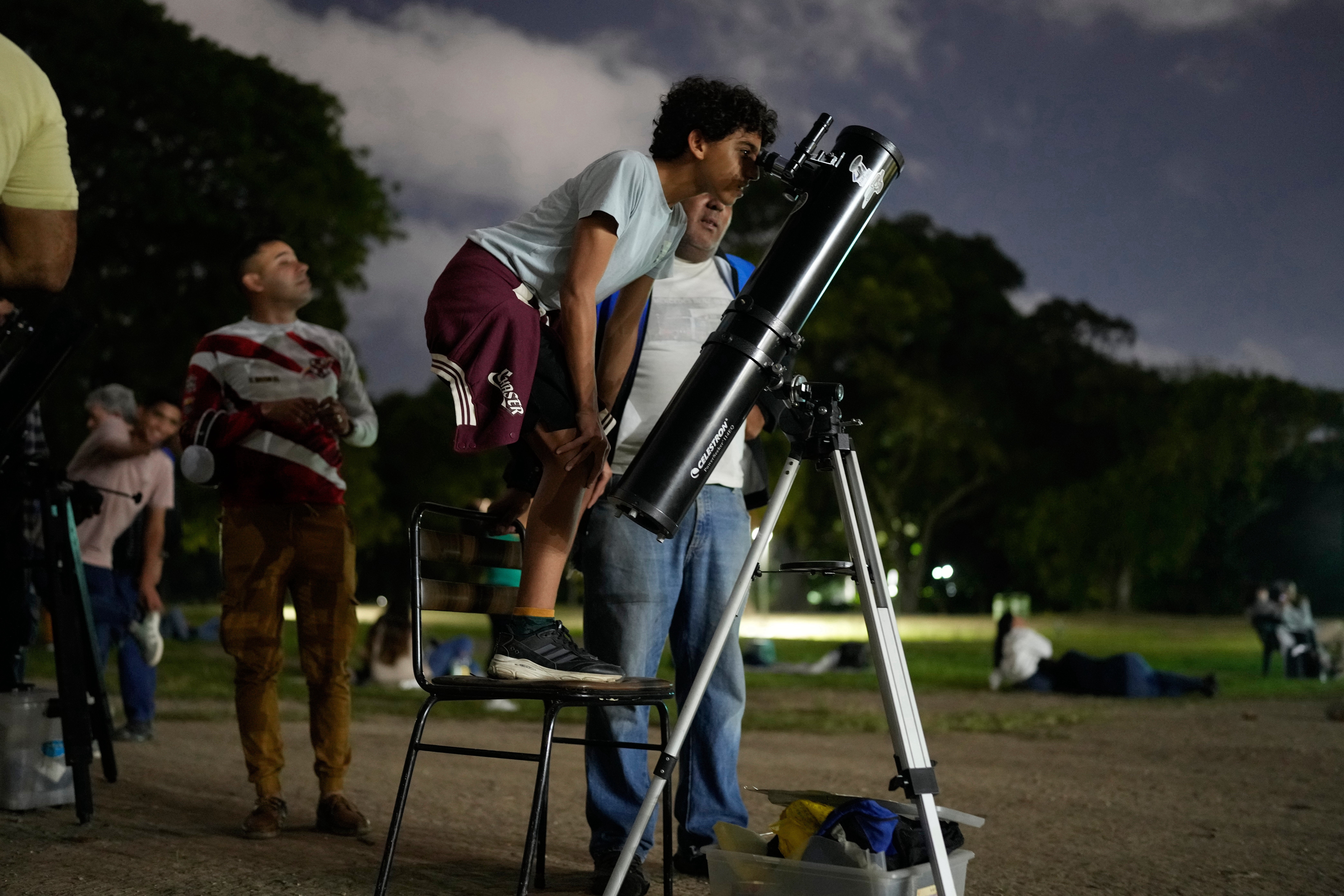 Un niño observa la luna a través de un telescopio durante un eclipse lunar en Caracas, Venezuela