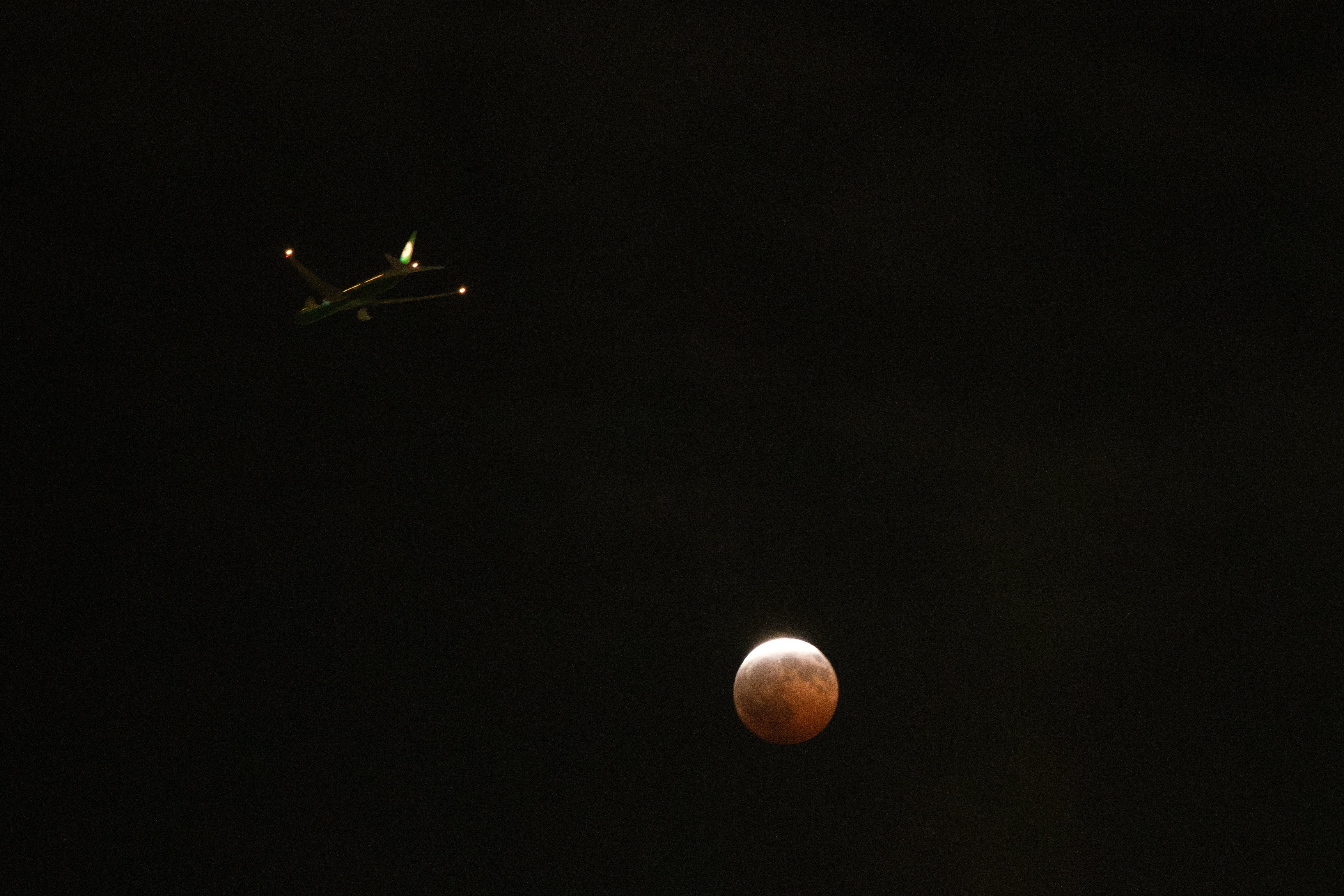 Un avión sobrevuela un eclipse lunar parcial en Los Ángeles