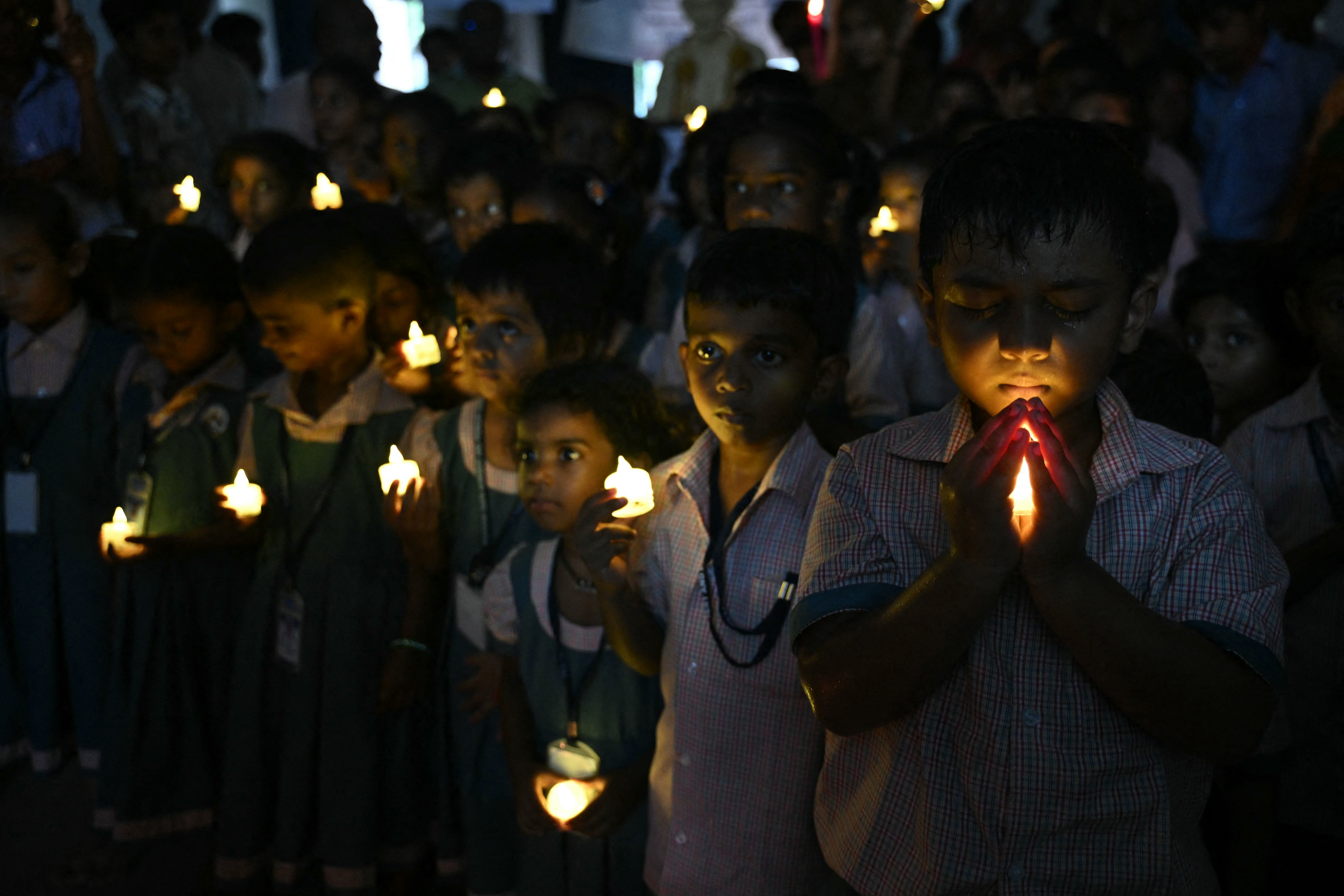 Unos escolares, con velas LED en la mano, se reúnen en Chennai para rendir homenaje a las víctimas de la riada repentina ocurrida en Nepal