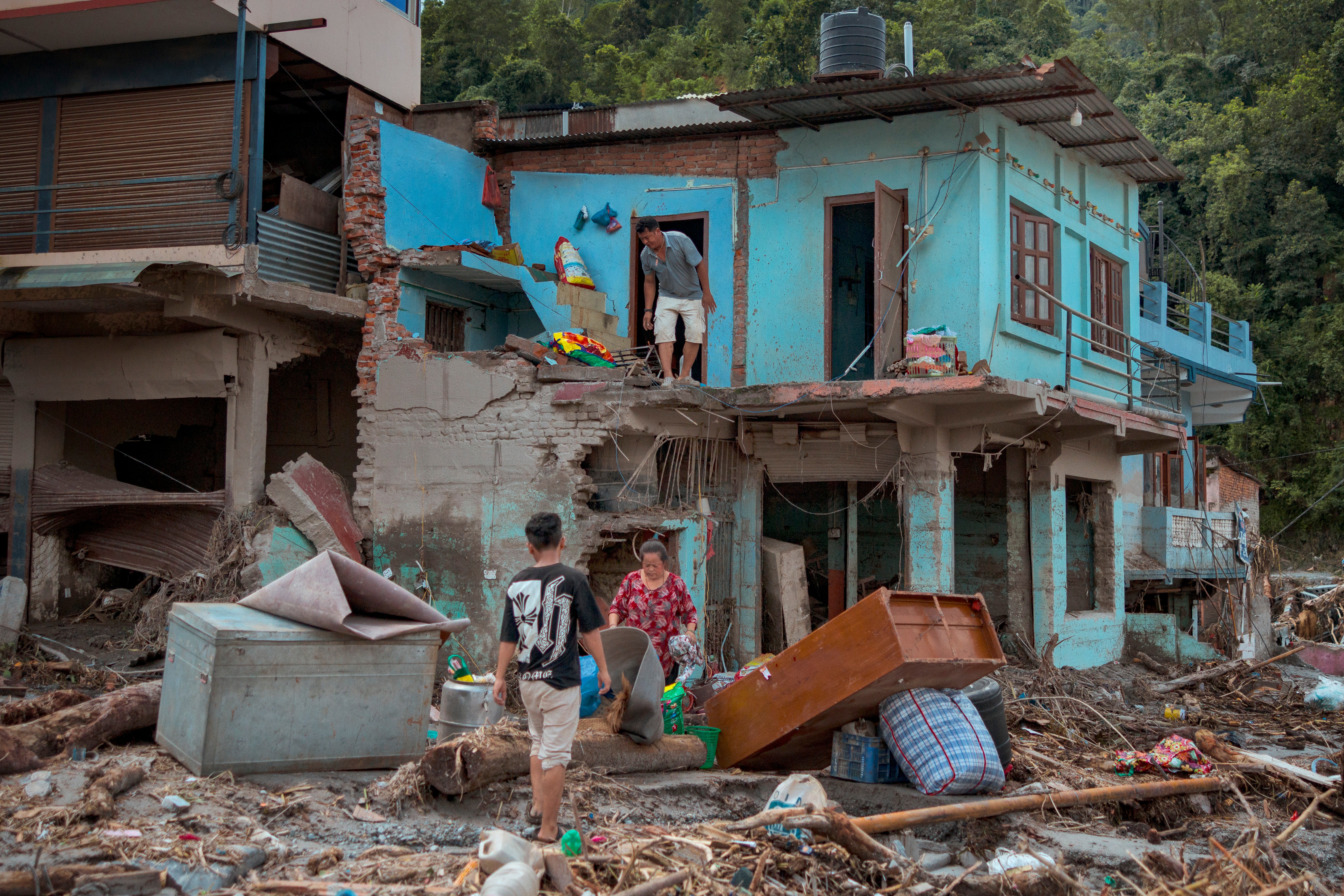 Los vecinos rescatan sus pertenencias de su casa destruida tras las riadas repentinas
