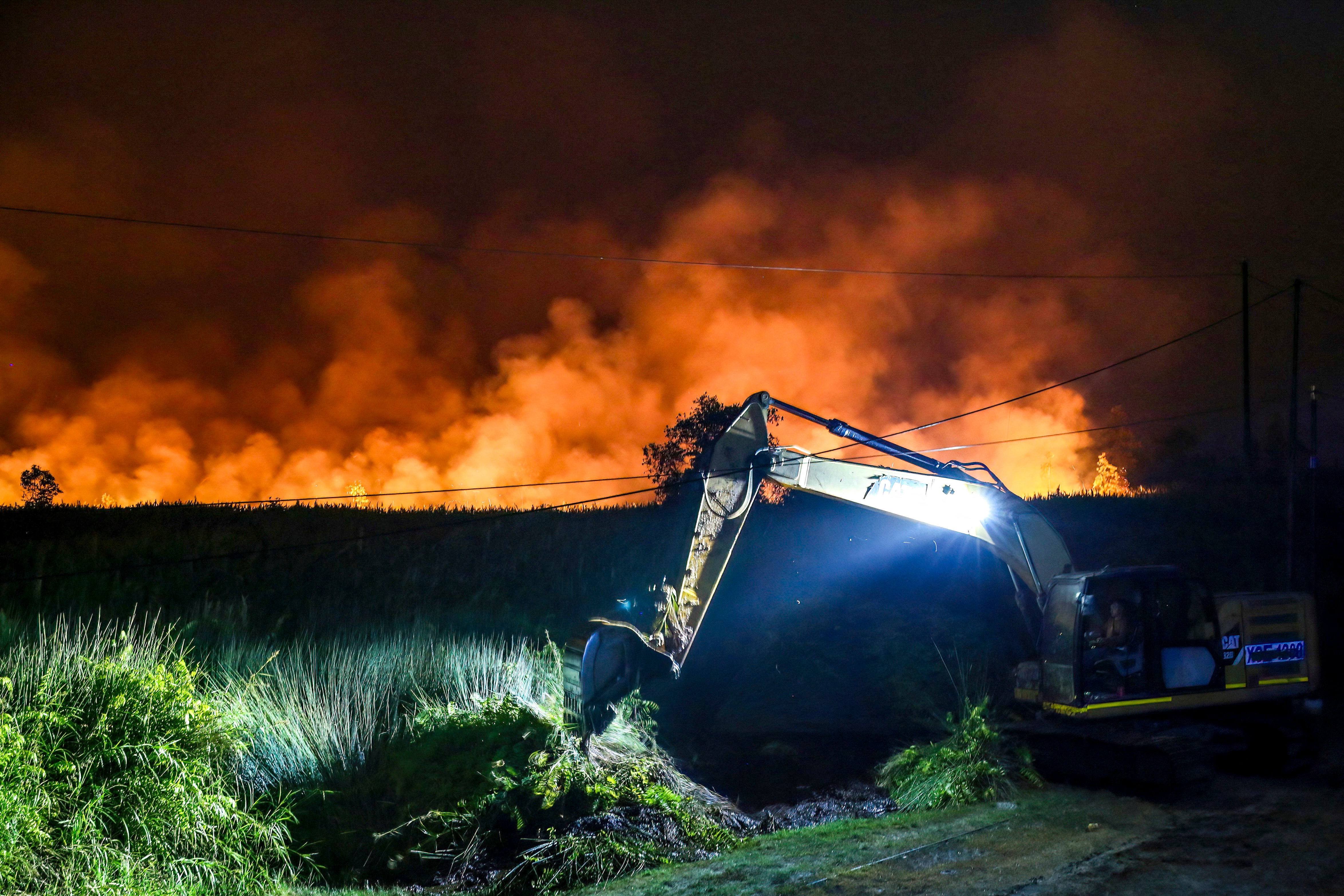 Una excavadora abre una zanja para intentar contener un incendio forestal en la zona de Tumbang Nusa, en Pulang Pisau