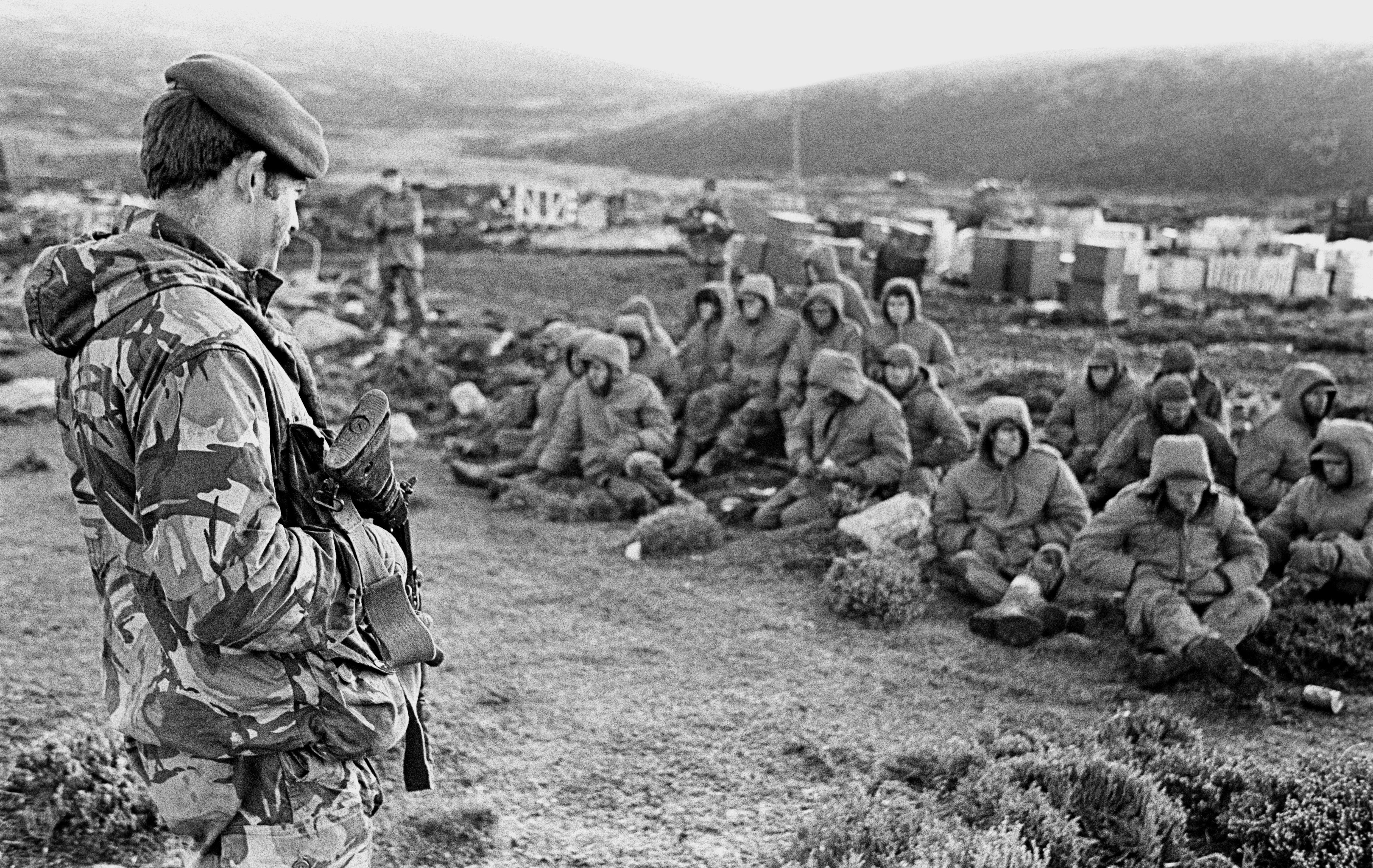 Soldados argentinos capturados en Goose Green son custodiados por un miembro de los Royal Marines el 2 de junio de 1982