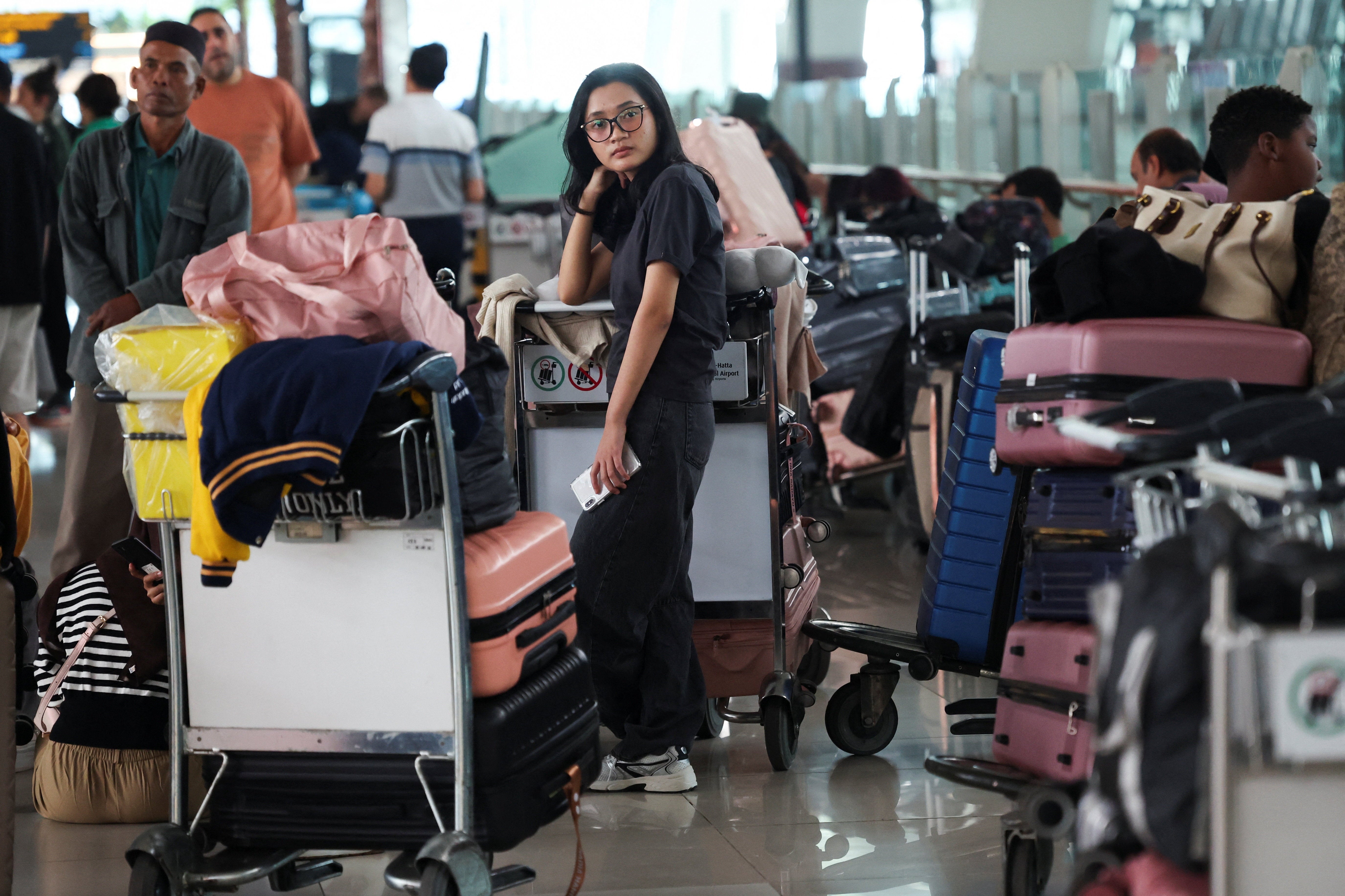 Un pasajero varado espera en una terminal del Aeropuerto Internacional Soekarno-Hatta, en Tangerang, tras el cierre de sus operaciones debido a la erupción del volcán Anak Krakatau