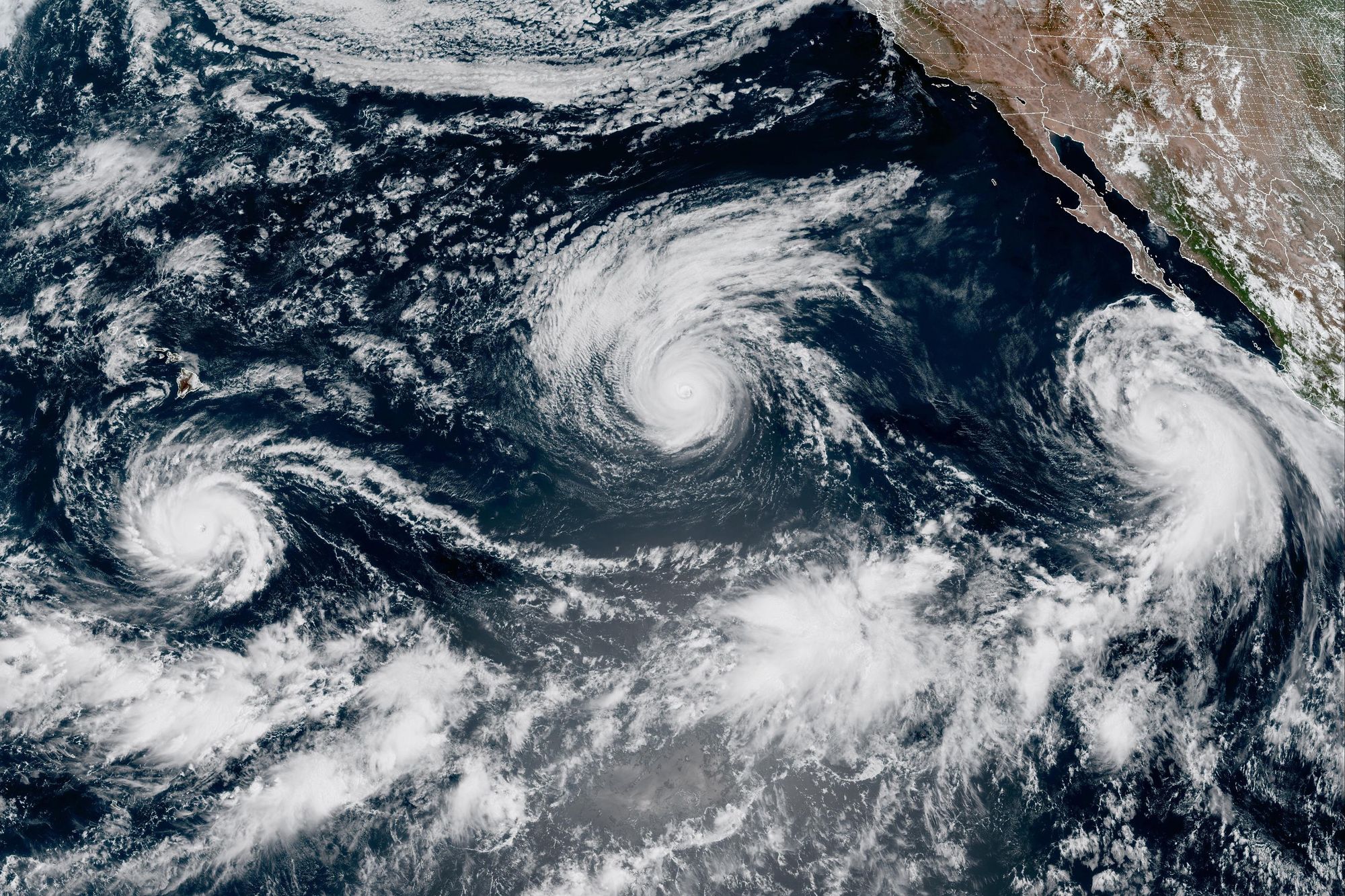 Esta imagen satelital proporcionada por el Instituto Cooperativo para la Investigación en la Atmósfera (CIRA) y la Oficina Nacional de Administración Oceánica y Atmosférica (NOAA) muestra tres tormentas, de izquierda a derecha: el huracán Lowell, el huracán Karina y la tormenta tropical Marie en el Océano Pacífico