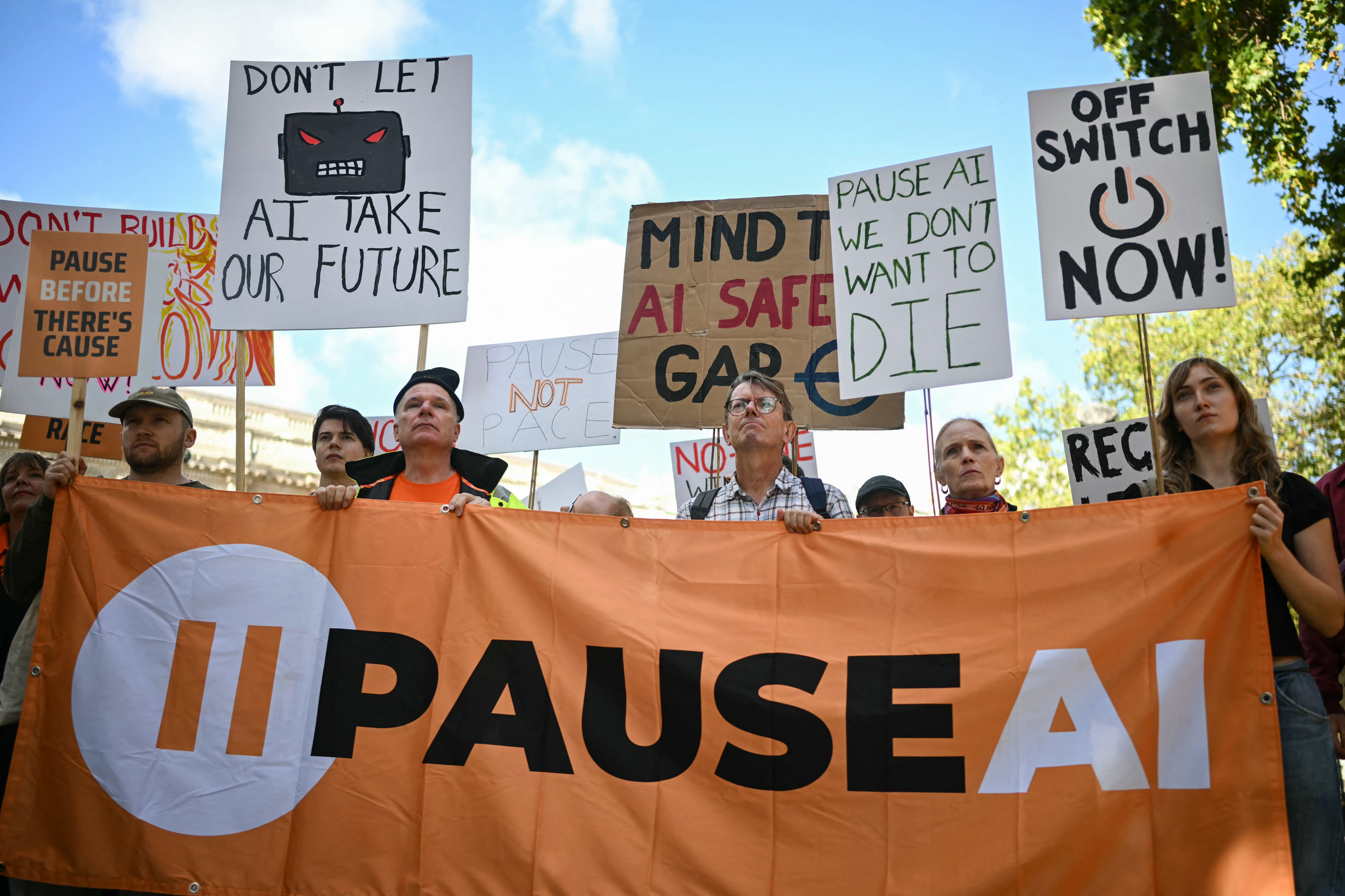 Un grupo de personas sostiene pancartas durante una protesta del grupo de acción cívica PauseAI UK frente a Downing Street, en el centro de Londres, el 16 de septiembre de 202