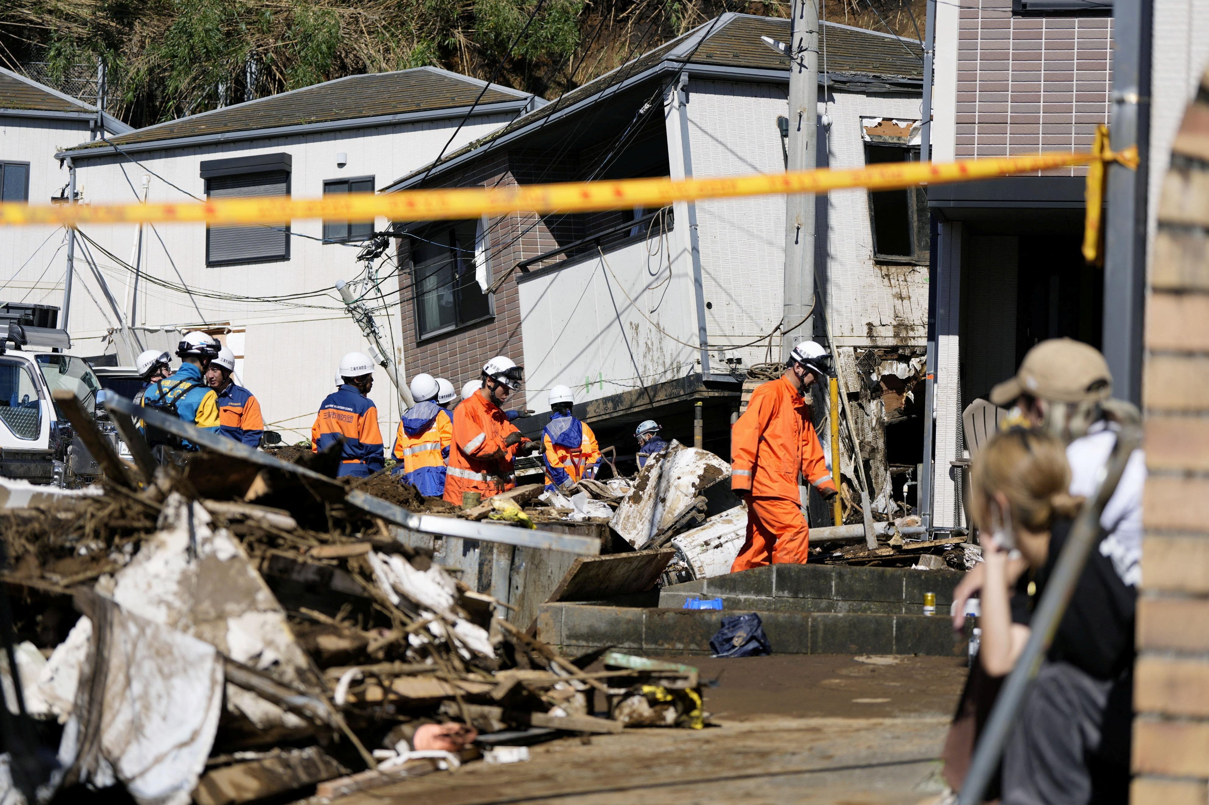 Los equipos de rescate realizan labores de búsqueda para localizar a una persona desaparecida en una vivienda afectada por un deslizamiento de tierra provocado por el tifón Dujuan en Miura, prefectura de Kanagawa, Japón