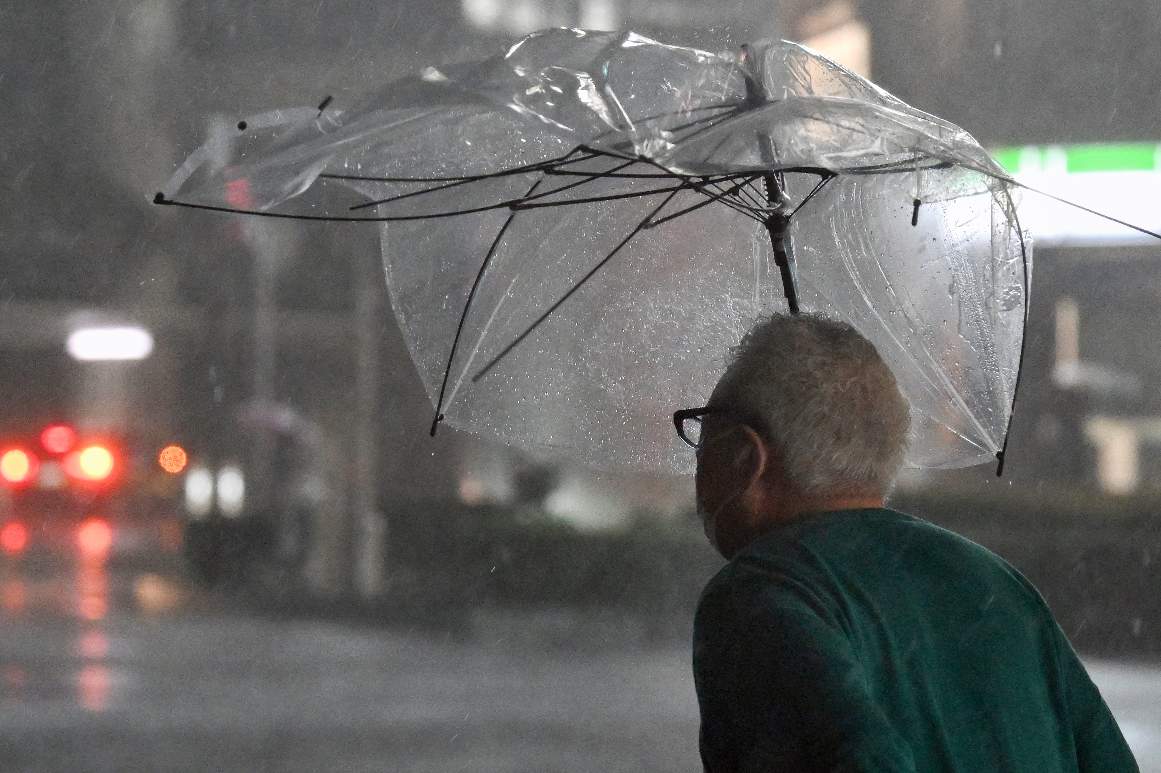 Un peatón camina con un paraguas roto bajo una intensa lluvia en Chiba, el 21 de septiembre de 2026