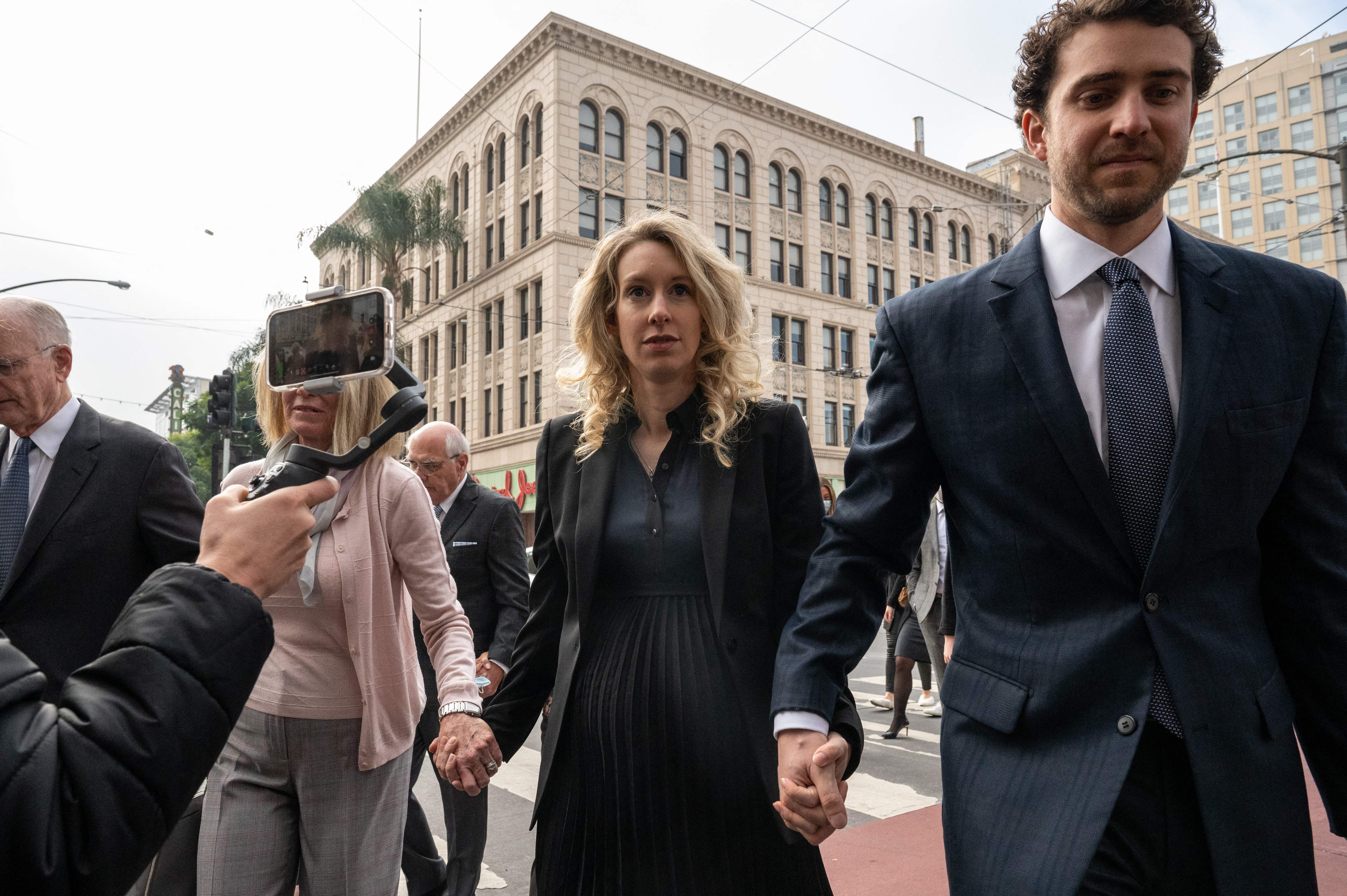 Elizabeth Holmes (centro) y su pareja, William Evans (derecha), fotografiados en 2022, son los protagonistas del nuevo documental