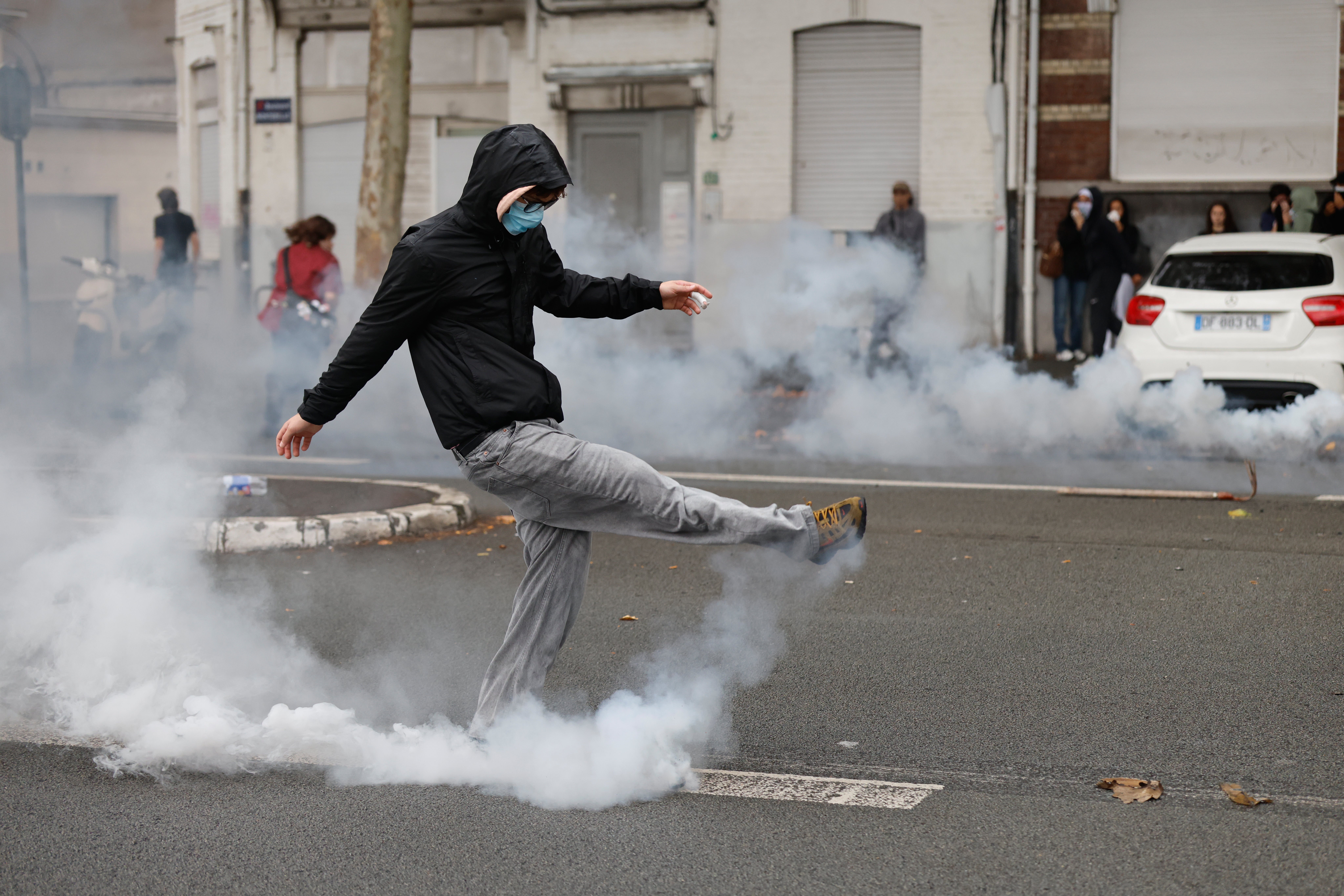 Un estudiante patea un bote de gas lacrimógeno durante las protestas en Lille, en las que se exigen más recursos para las escuelas