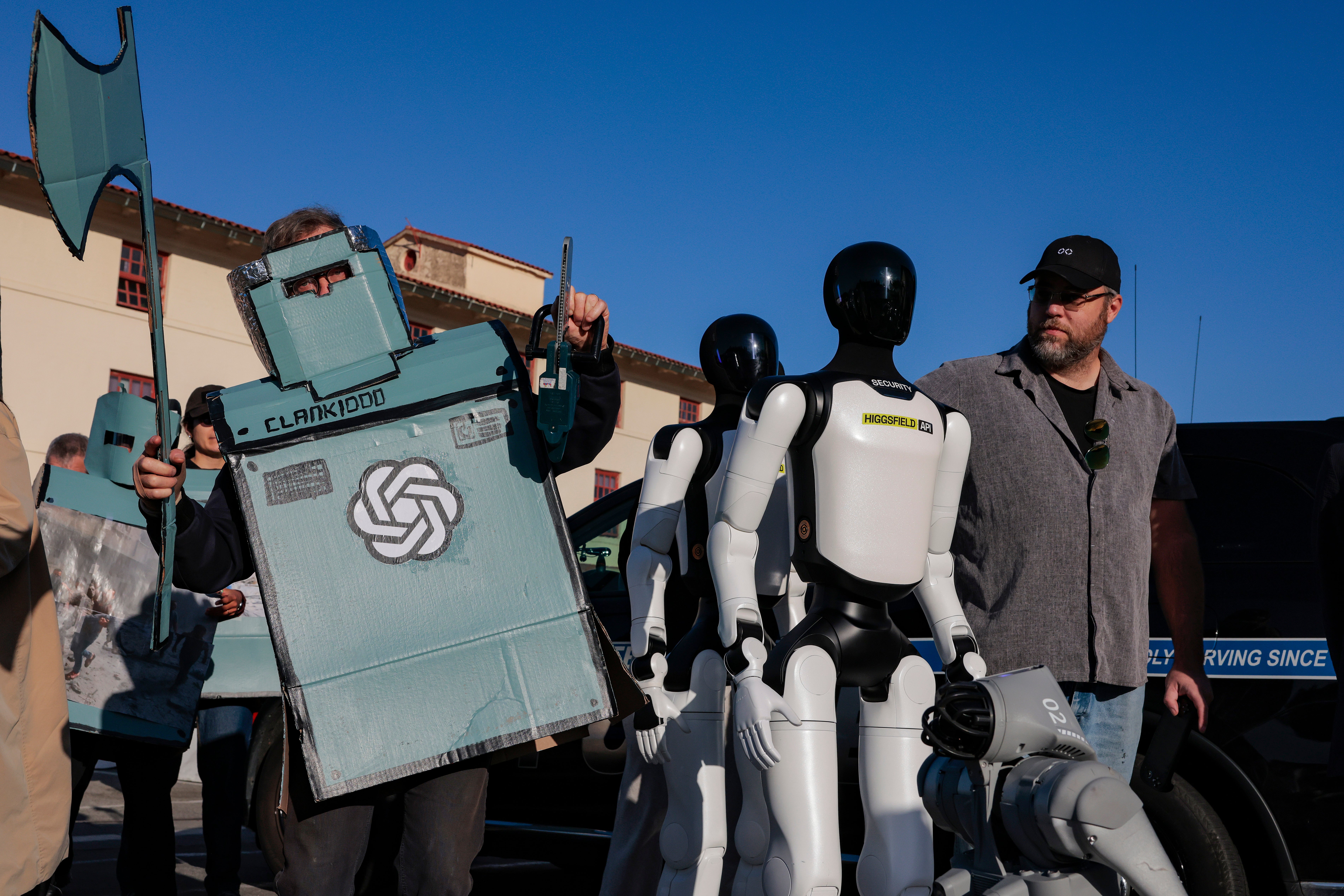 Robots humanoides, un perro robot y manifestantes disfrazados de robots aparecen uno al lado del otro en una manifestación contra la IA celebrada frente a una conferencia de desarrolladores de OpenAI en Fort Mason, el 29 de septiembre de 2026, en San Francisco, California