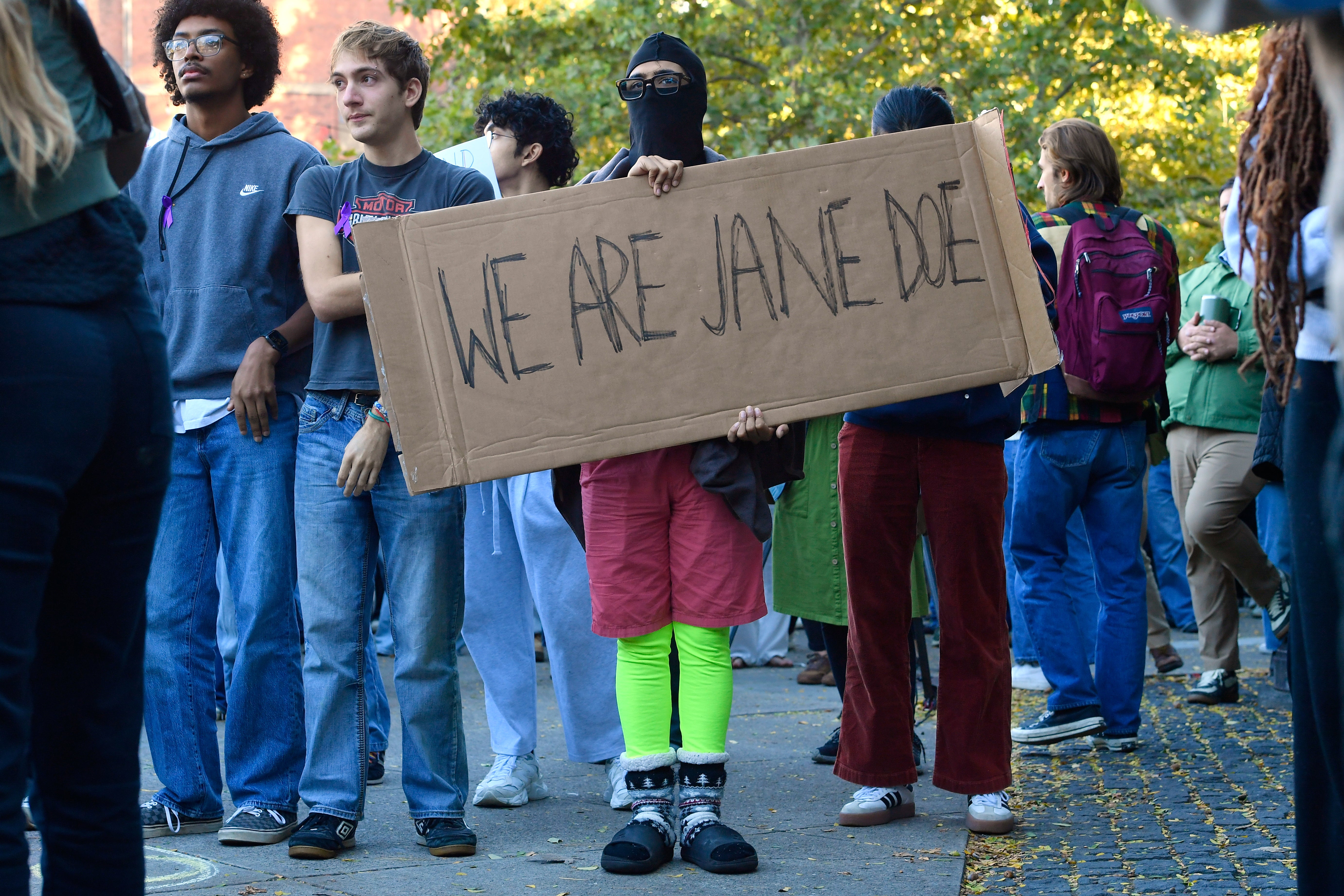 Una manifestante sostiene un cartel en el que se lee “somos Jane Doe” durante una protesta contra la gestión de la Universidad de Cornell en relación con la presunta violación en grupo