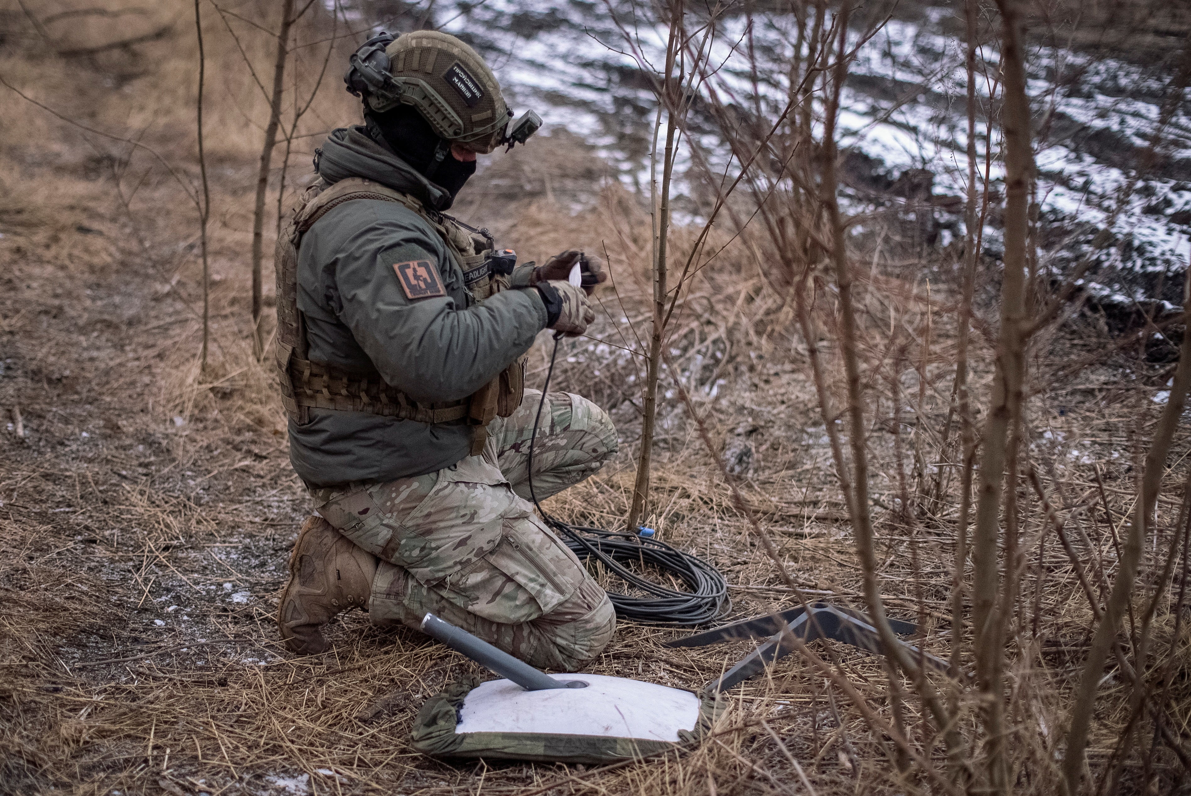 Un militar ucraniano de la 47ª brigada prepara un sistema de Internet por satélite Starlink cerca de Avdiivka, Ucrania, en 2024