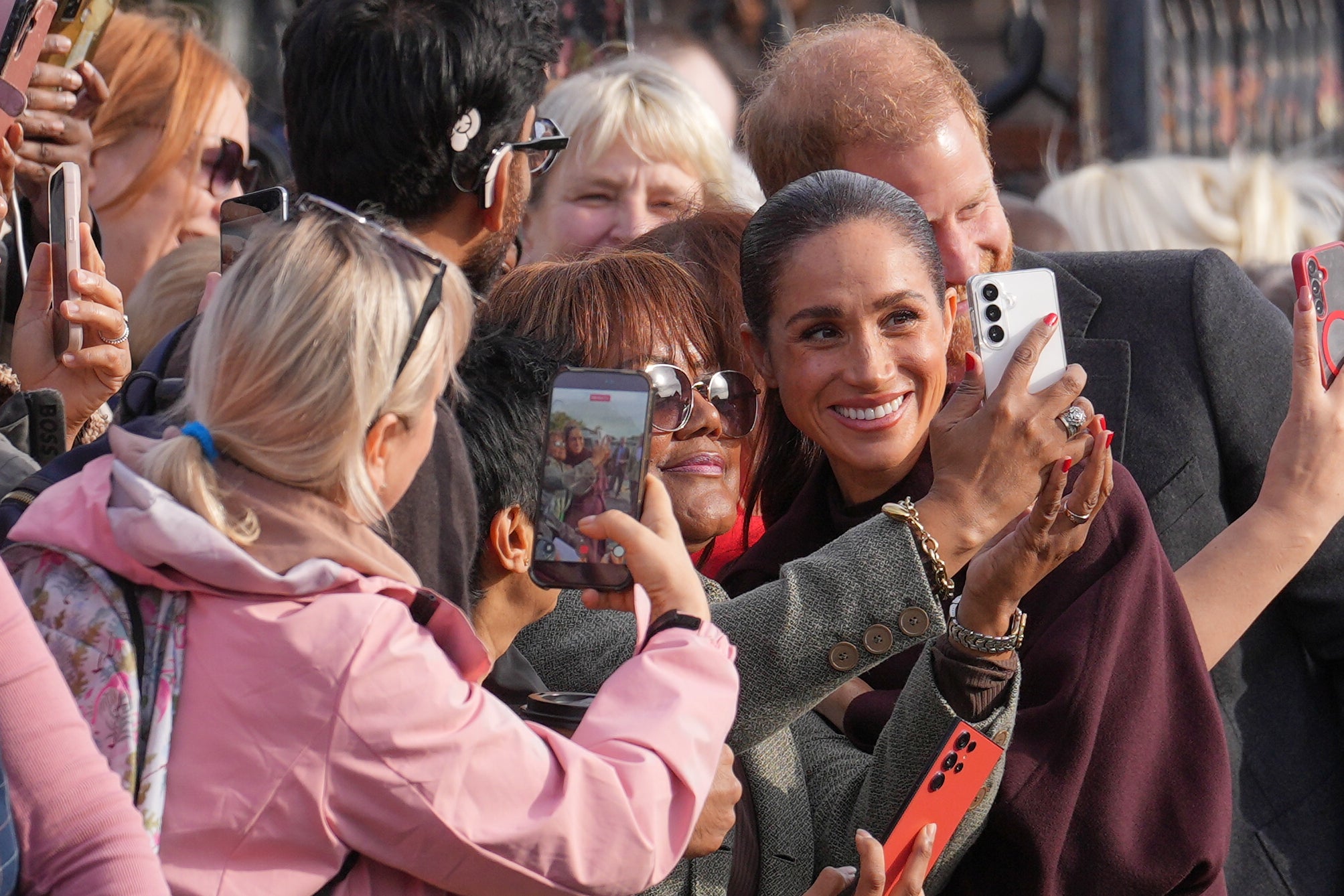 El príncipe Enrique y Meghan reciben vítores en su regreso al Reino Unido